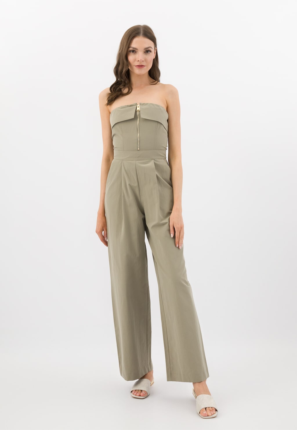 Beżowe klapki damskie Wojas model 74122-54 z tłoczoną skórą i złotym obcasem, widoczne na modelce noszącej elegancki beżowy kombinezon.