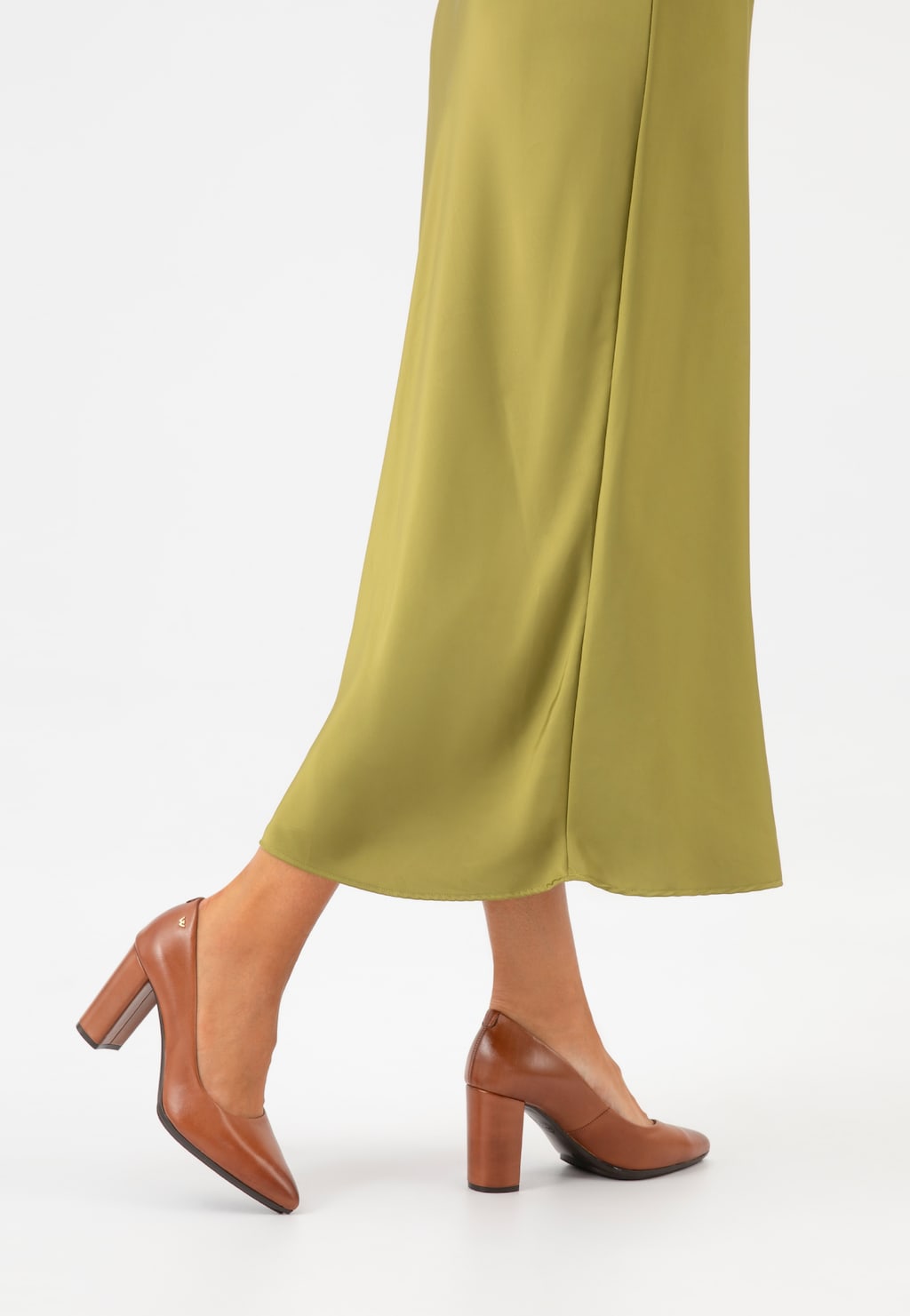 Brązowe czółenka Wojas model 35072-52 ze skóry licowej z grubym obcasem, pokazane na nodze kobiety ubranej w oliwkową, długą spódnicę, widok z profilu.