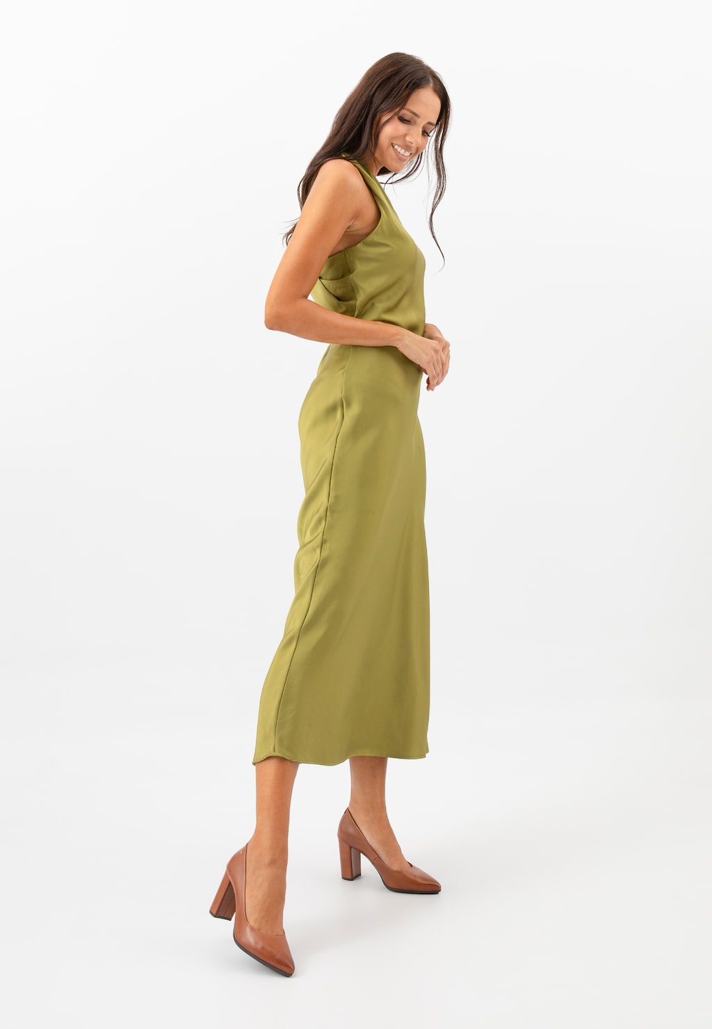 Kobieta w oliwkowej sukience prezentująca brązowe czółenka Wojas model 35072-52 ze skóry licowej na stabilnym obcasie, idealne do eleganckich stylizacji.