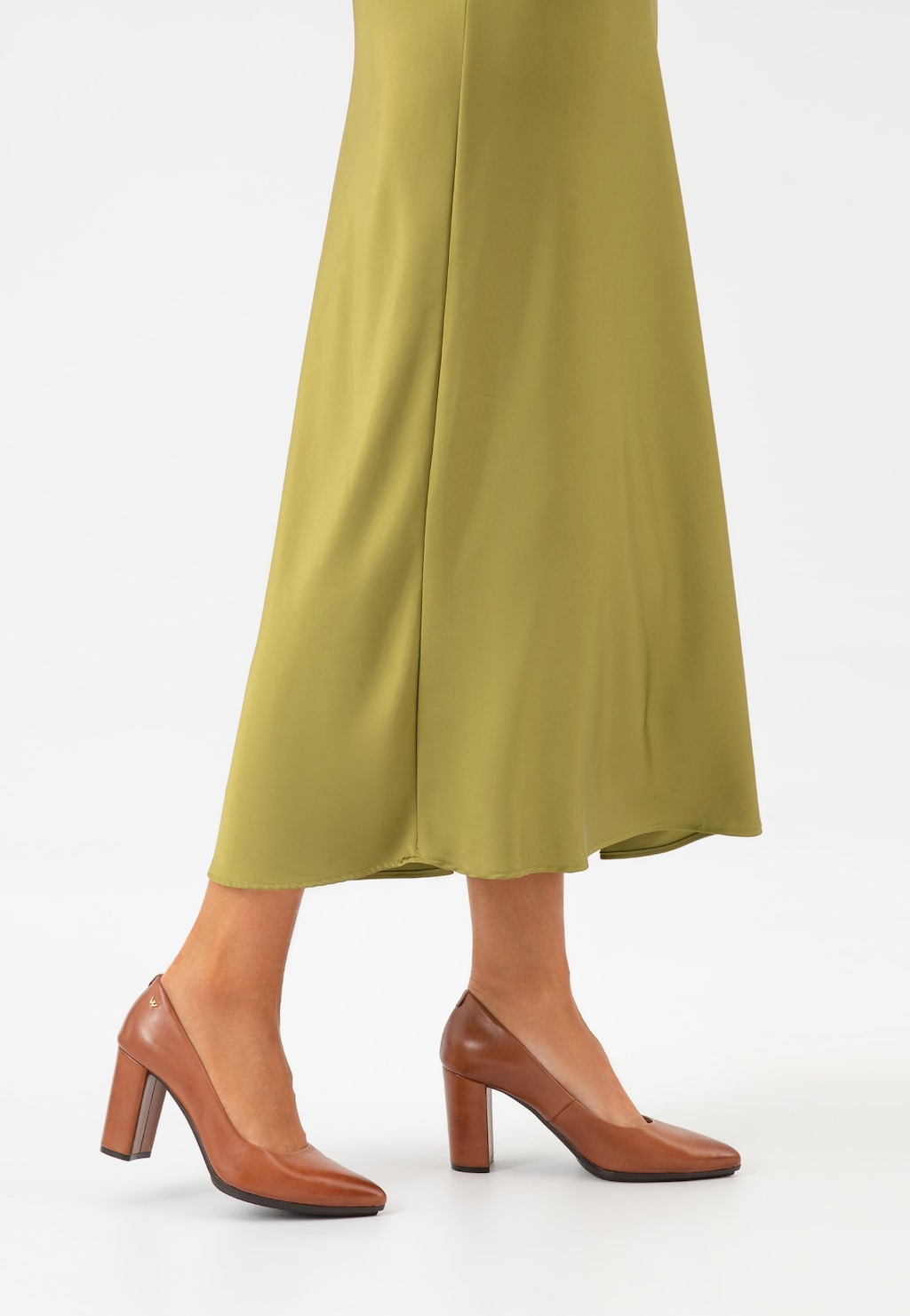 Brązowe czółenka Wojas 35072-52 ze skóry licowej na stabilnym obcasie, zestawione z oliwkową, długą spódnicą. Eleganckie buty widoczne z profilu.