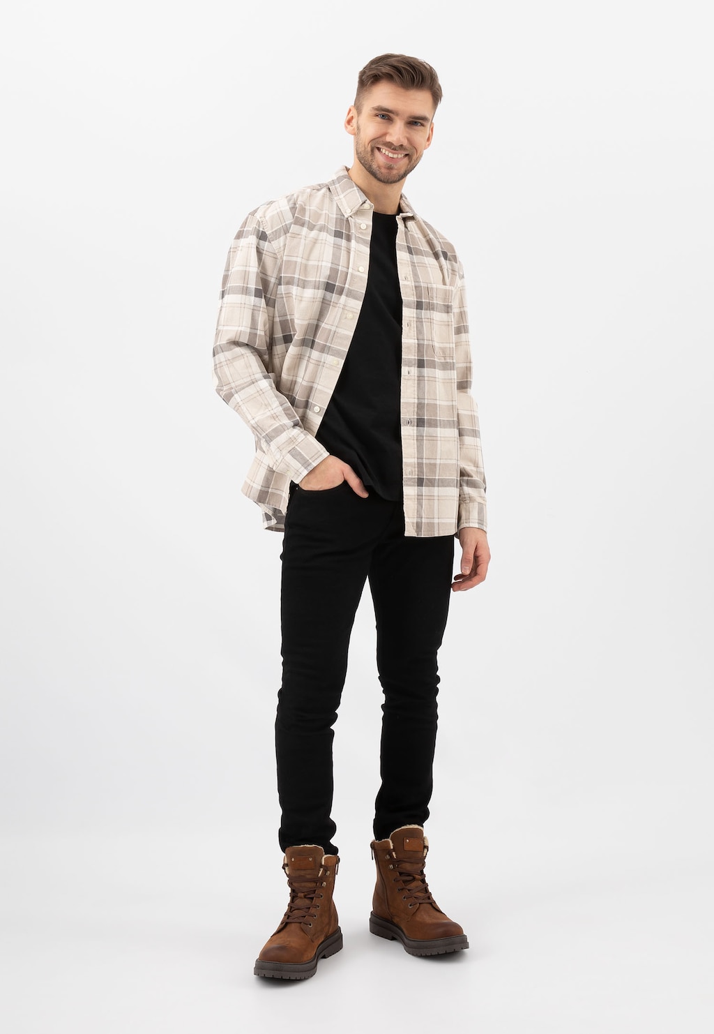 Model w stylizacji z brązowymi trzewikikami Wojas 24077-93 typu bikery z ociepleniem, ubrany w kraciastą koszulę i czarne spodnie.