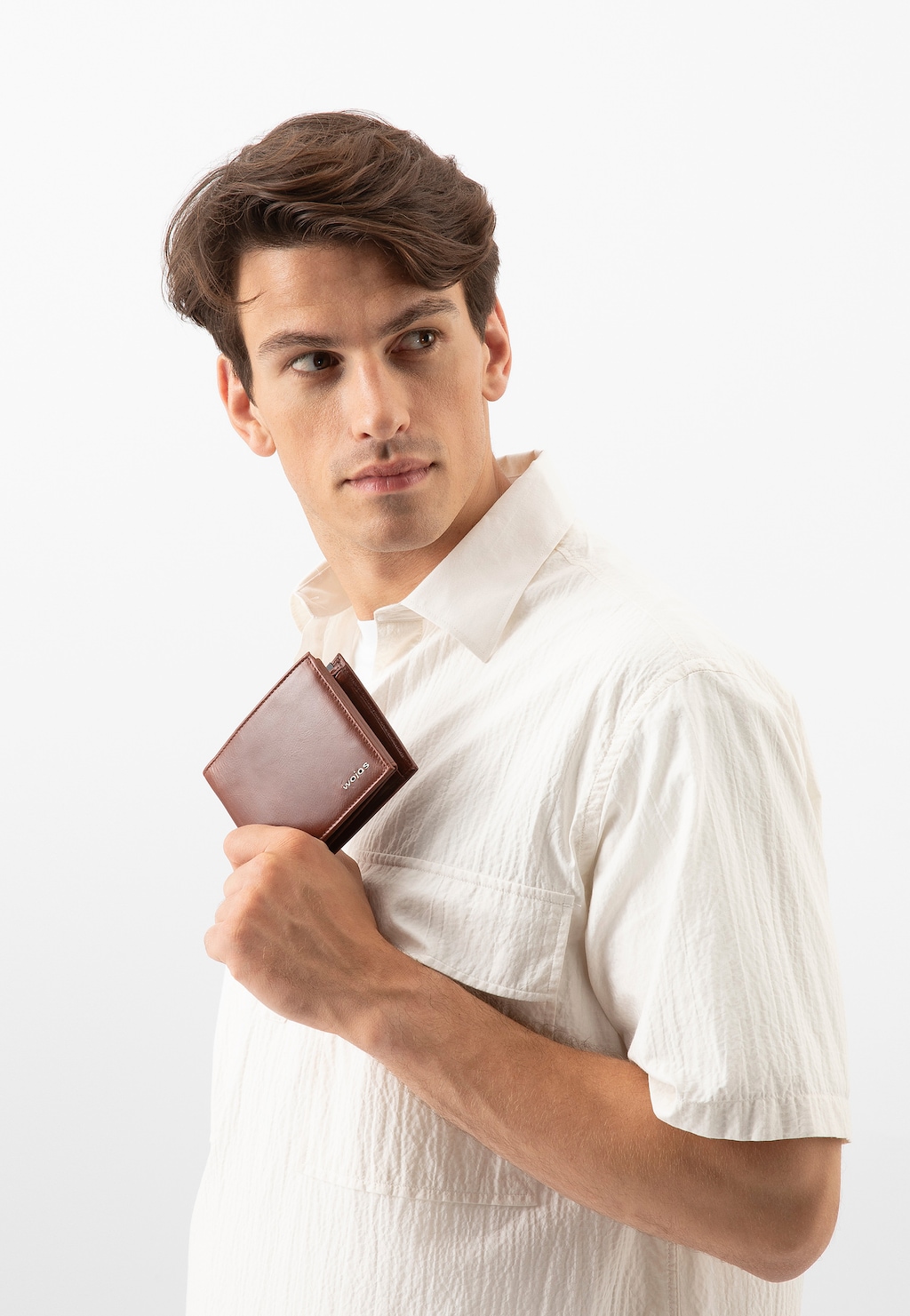Elegancki brązowy skórzany portfel męski Wojas 8938-53 z ochroną RFID, prezentowany przez modela w białej koszuli na jasnym tle.