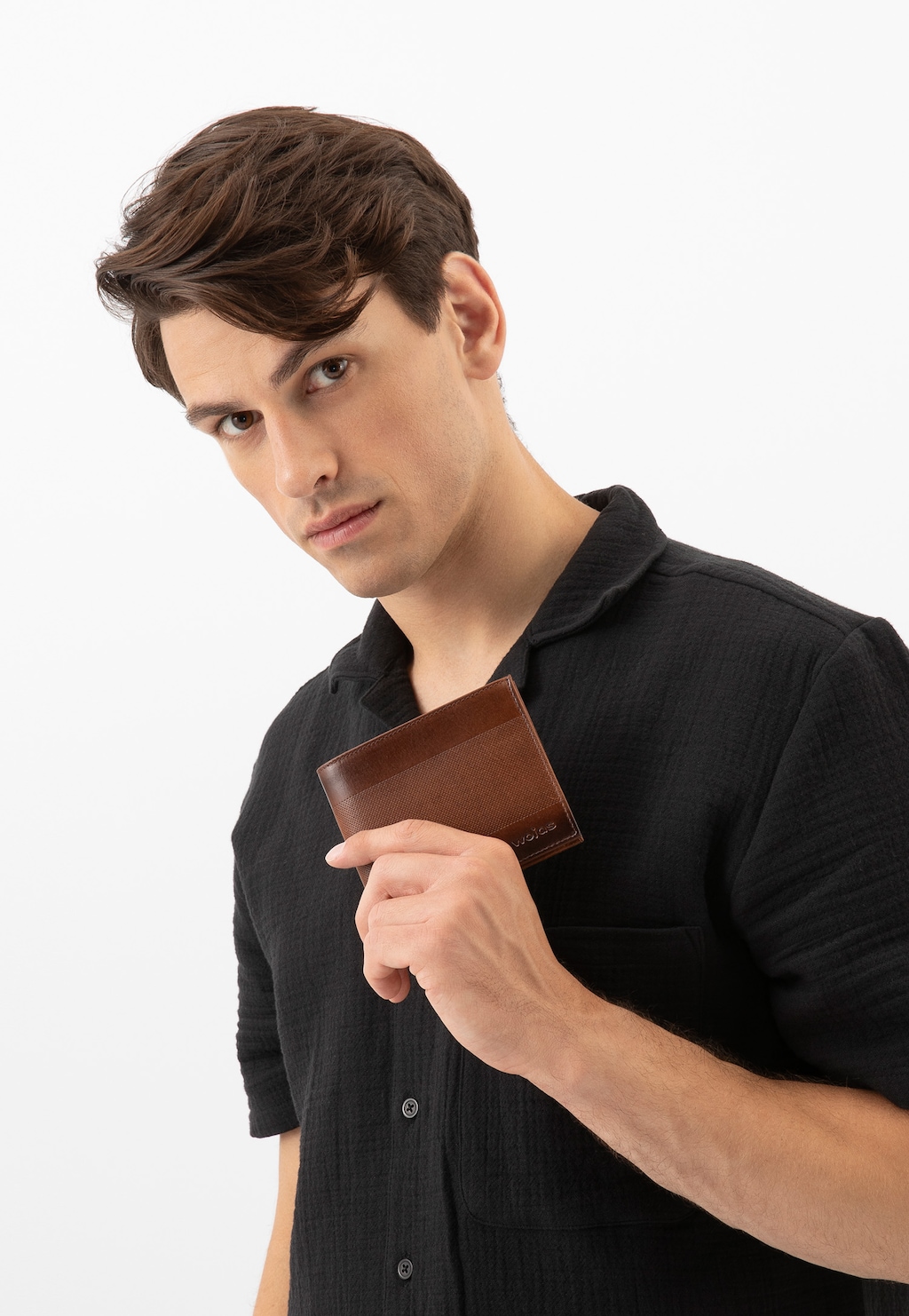 Brązowy cieniowany portfel męski Wojas 91080-92 z dziurkowaną teksturą, trzymany w dłoni, prezentujący elegancki design i praktyczność dla nowoczesnego mężczyzny.