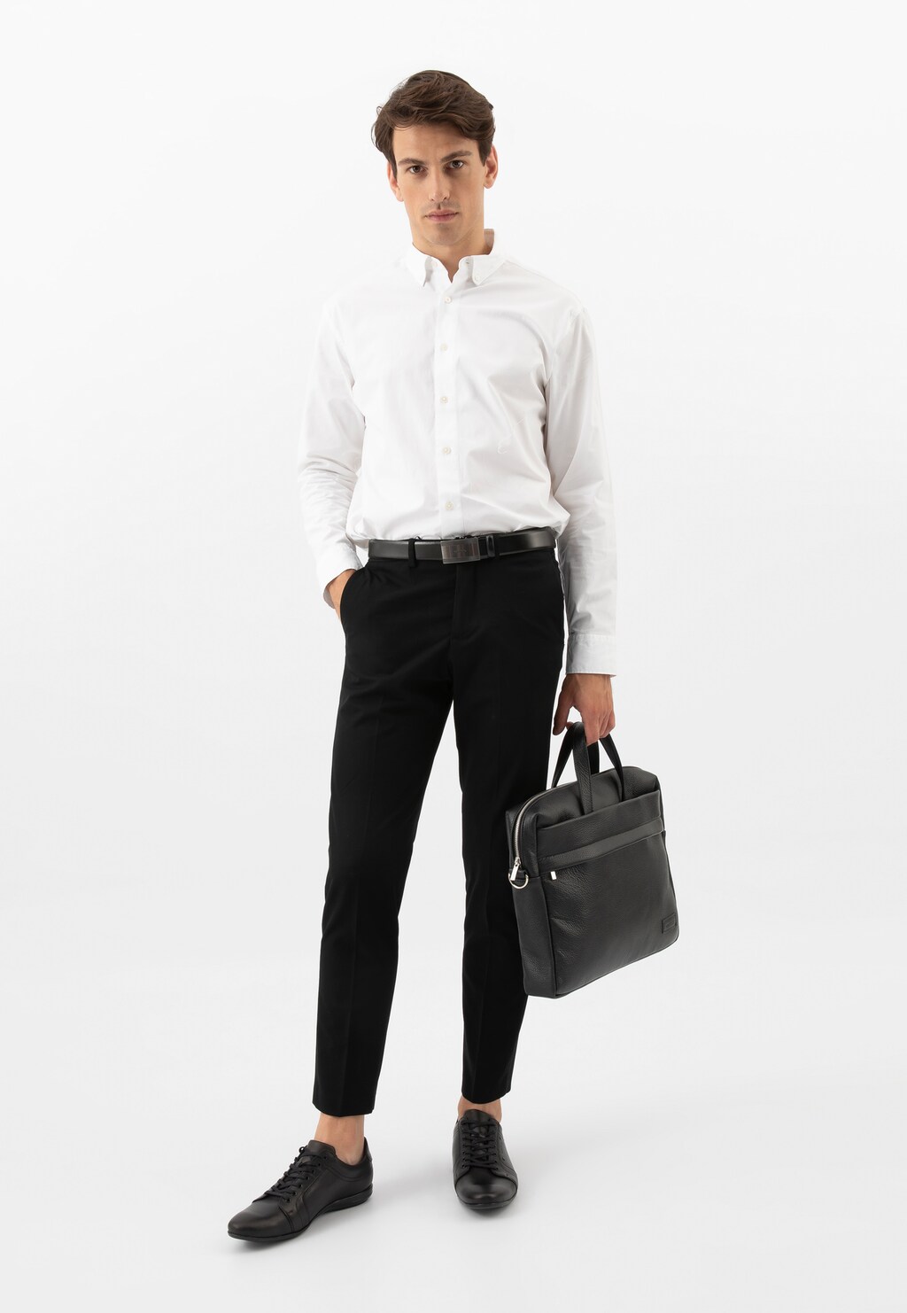 Mężczyzna w eleganckim stroju biznesowym trzymający czarną skórzaną torbę męską Wojas model 80071-51 z przegrodą na laptopa, idealna do pracy i spotkań biznesowych.