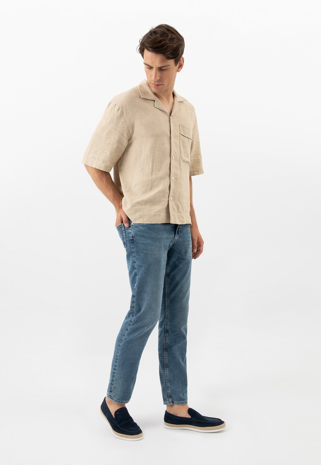 Model w beżowej koszuli i jeansach prezentuje granatowe mokasyny męskie Wojas 10219-66 z ozdobnym jutowym sznurkiem, ukazując idealny casual look na lato.