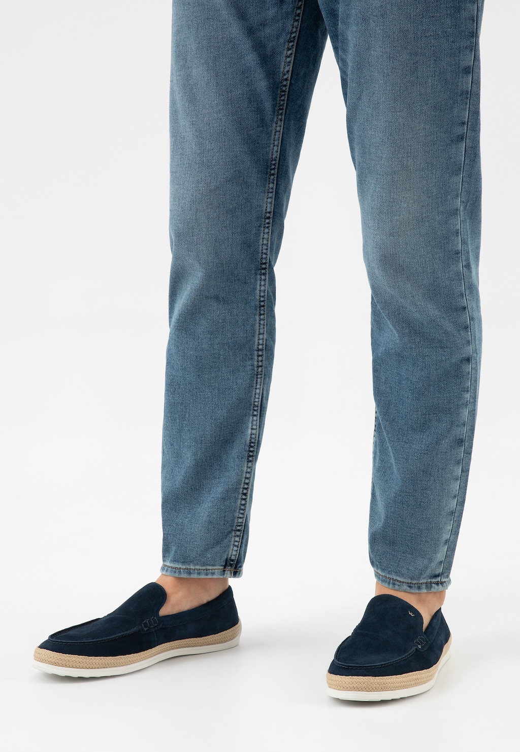 Granatowe mokasyny męskie Wojas model 10219-66 z ozdobnym jutowym sznurkiem, noszone z jasnymi jeansami. Buty mają beżową podeszwę jutową i elegancki zamszowy wygląd.