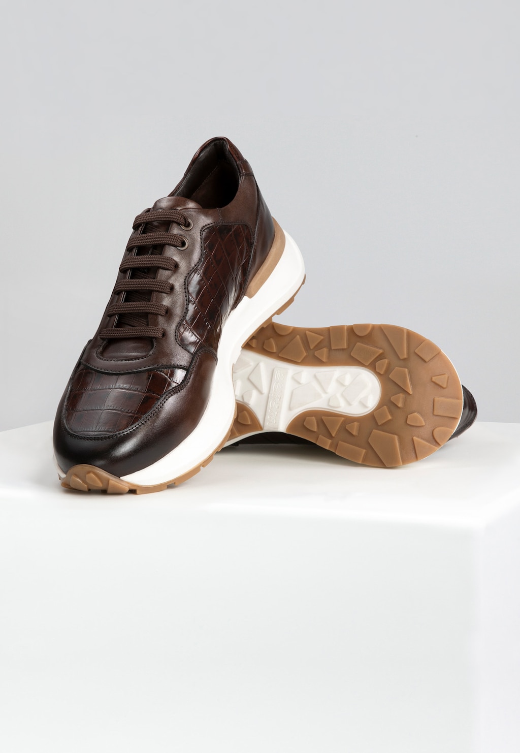 Brązowe sneakersy męskie Wojas PREMIUM model 10214-52 z eleganckim tłoczeniem, białą podeszwą i gumowym bieżnikiem. Widok z boku pokazujący stylowy profil butów.