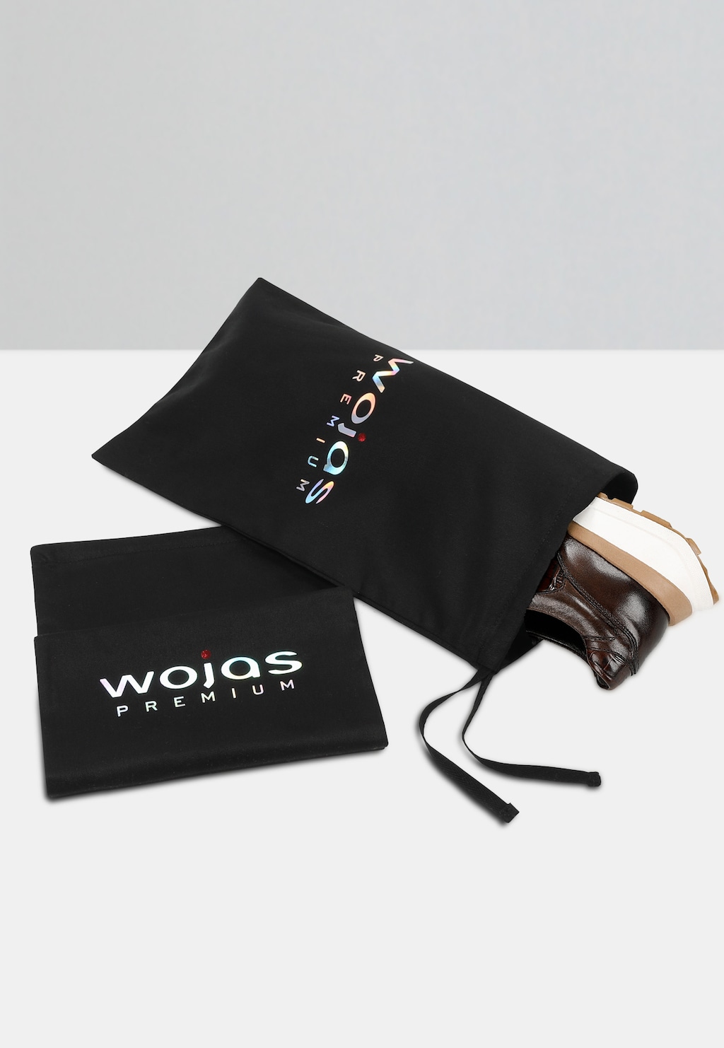 Brązowe sneakersy męskie Wojas PREMIUM model 10214-52 w czarnym woreczku ochronnym z logo marki, widoczna część buta z tłoczonym wzorem i jasną podeszwą.