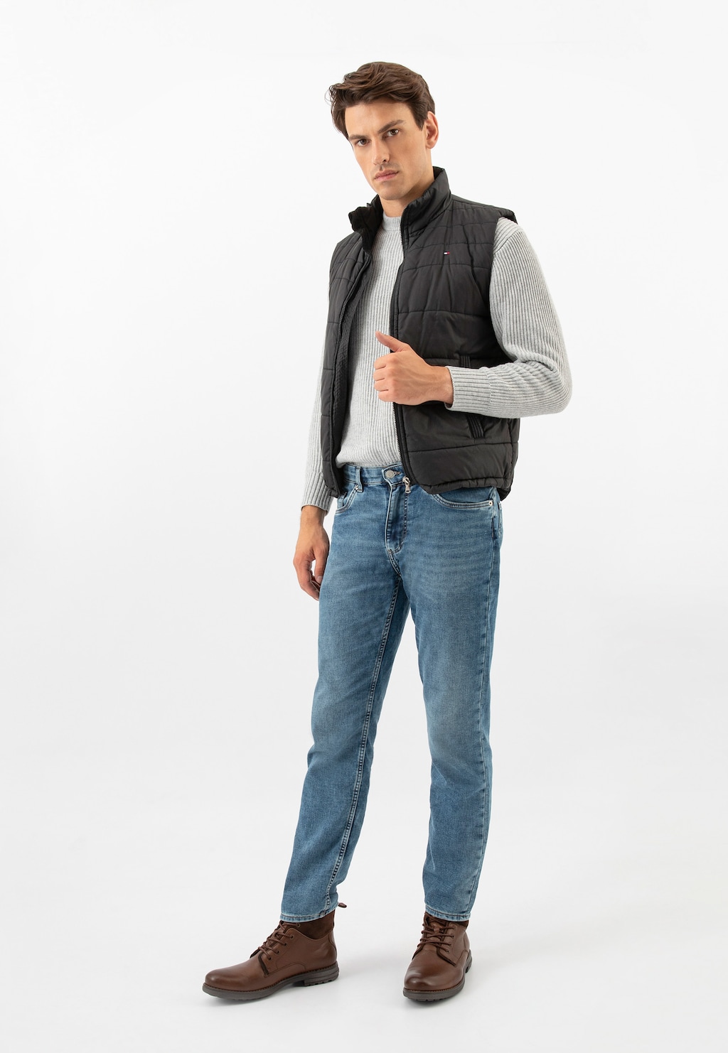 Model ubrany w casualowy strój z jeansami i szarym swetrem, prezentujący brązowe trzewiki męskie Wojas model 24094-72 w stylu miejskim, doskonałe do codziennych stylizacji.