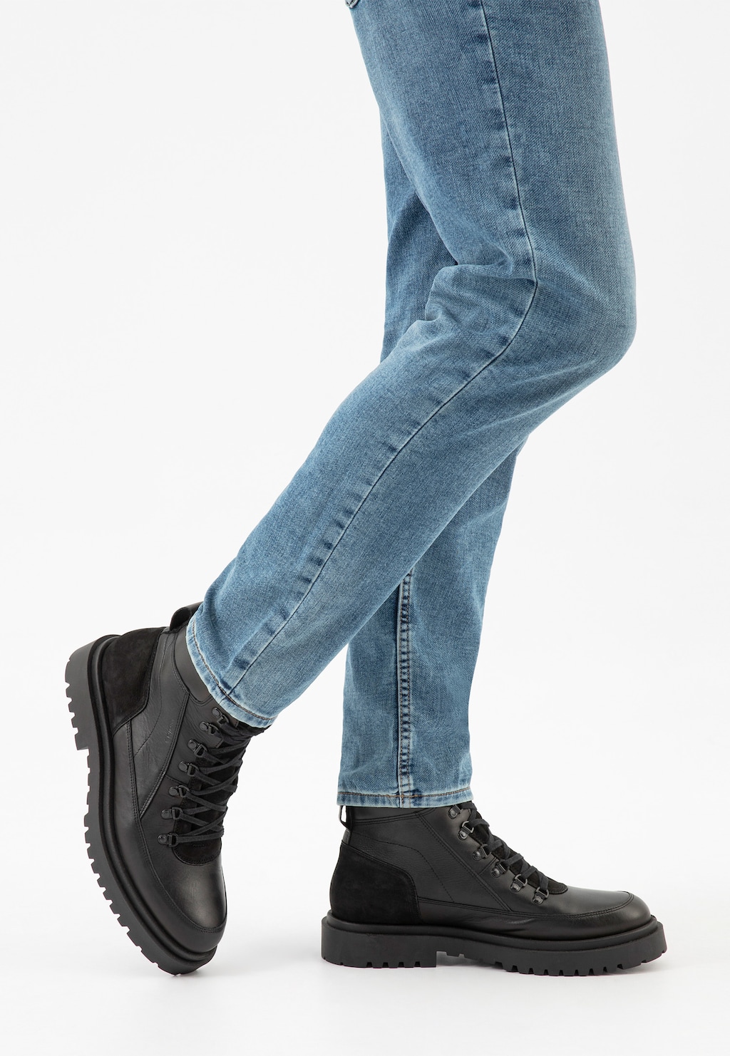 Czarne męskie bikery Wojas model 24089-71 z ociepleniem prezentowane na nodze w niebieskich jeansach. Buty posiadają masywną podeszwę i sznurowanie, idealne na zimowe dni.