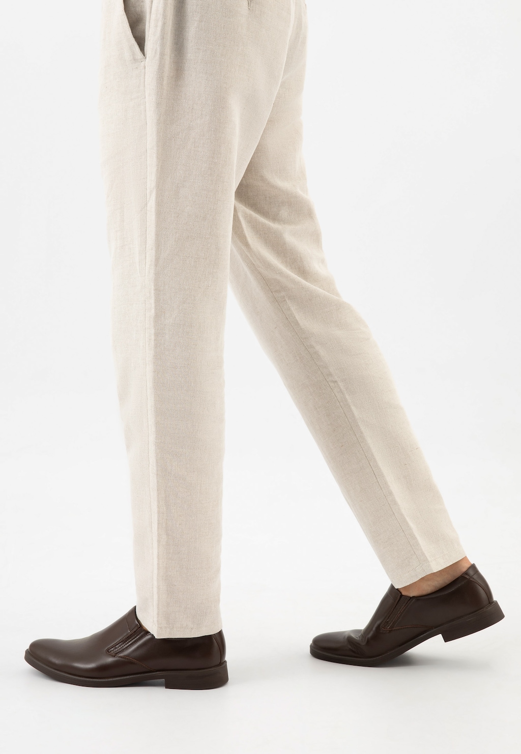 Eleganckie brązowe półbuty wsuwane Wojas model 10221-52 ze skóry licowej, widoczne na nodze mężczyzny w jasnych lnianych spodniach, prezentowane w ruchu.