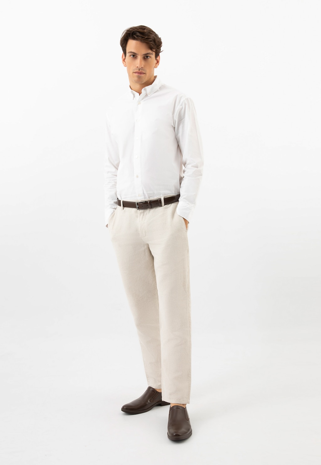 Model w białej koszuli i jasnych spodniach prezentujący brązowe półbuty wsuwane Wojas model 10221-52 ze skóry licowej, eleganckie połączenie do biznesowej stylizacji.