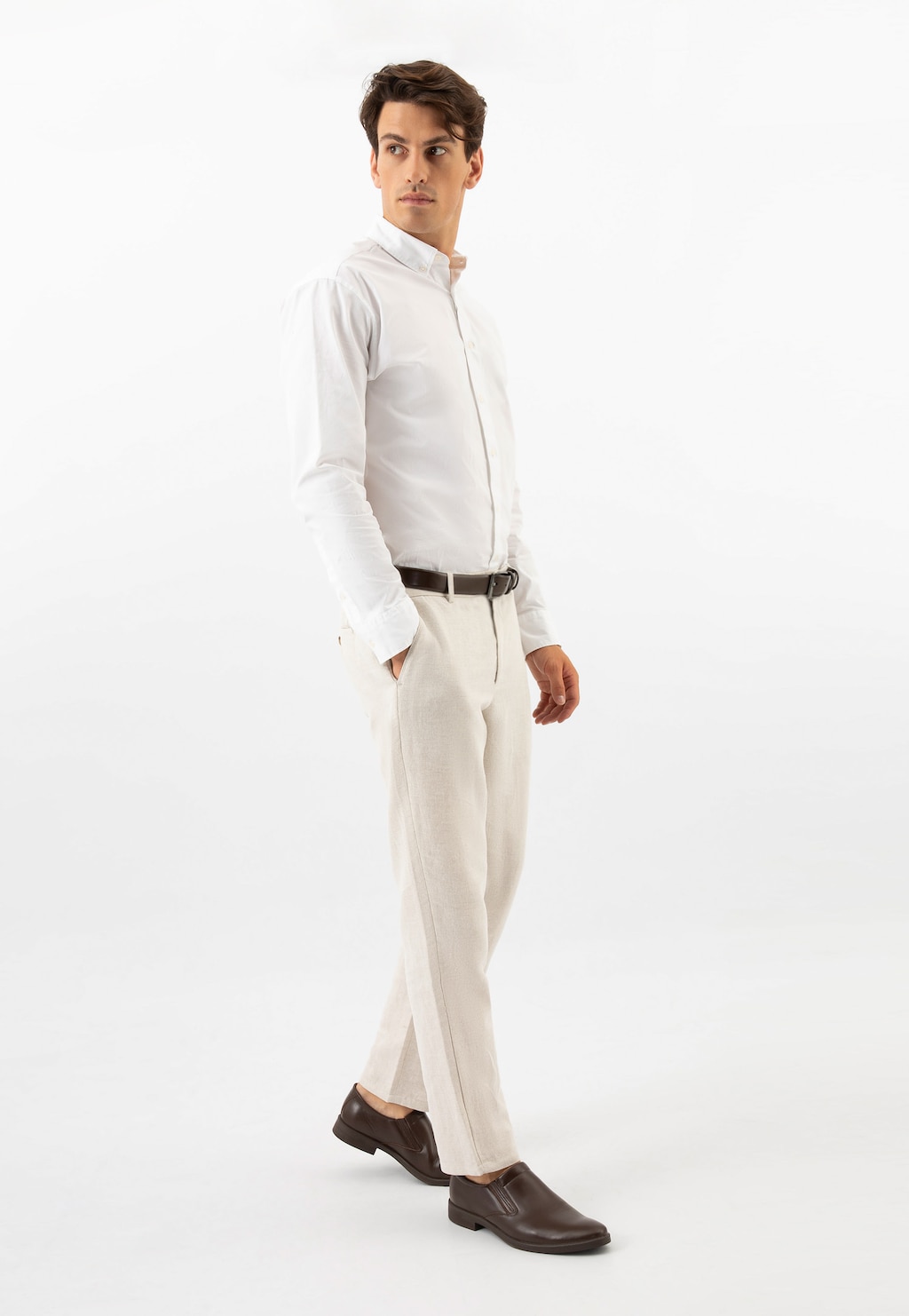 Elegancki mężczyzna w białej koszuli i jasnych spodniach prezentujący brązowe wsuwane półbuty Wojas model 10221-52 ze skóry licowej, idealne do stylizacji biznesowej.