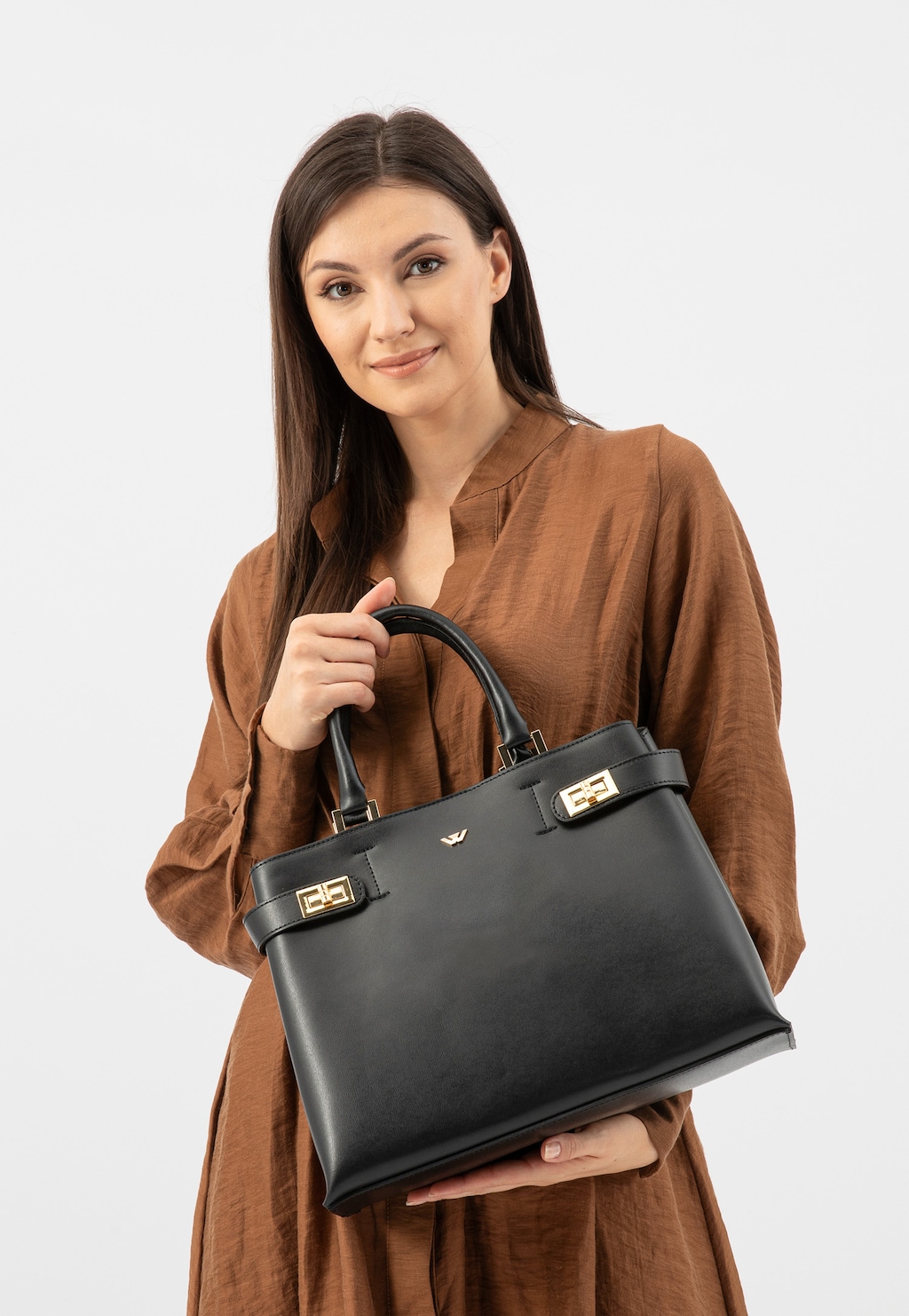 Elegancki czarny skórzany kuferek damski Wojas model 80403-51 ze złotymi detalami, prezentowany przez osobę w brązowej sukience na jasnym tle.