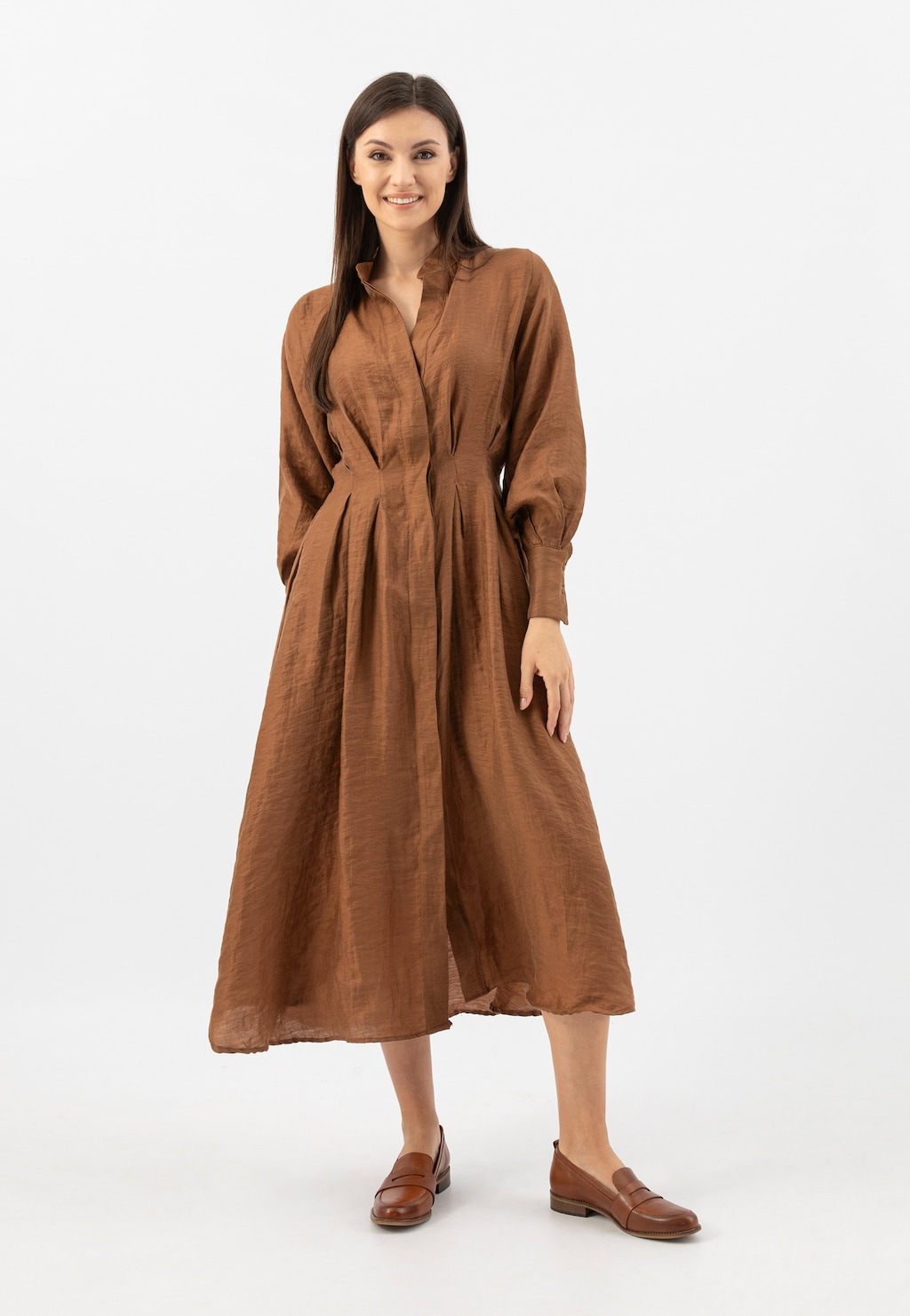 Kobieta w brązowej sukience midi prezentuje jasnobrązowe mokasyny damskie Wojas ze skóry licowej model 46004-53, idealne do eleganckich stylizacji.