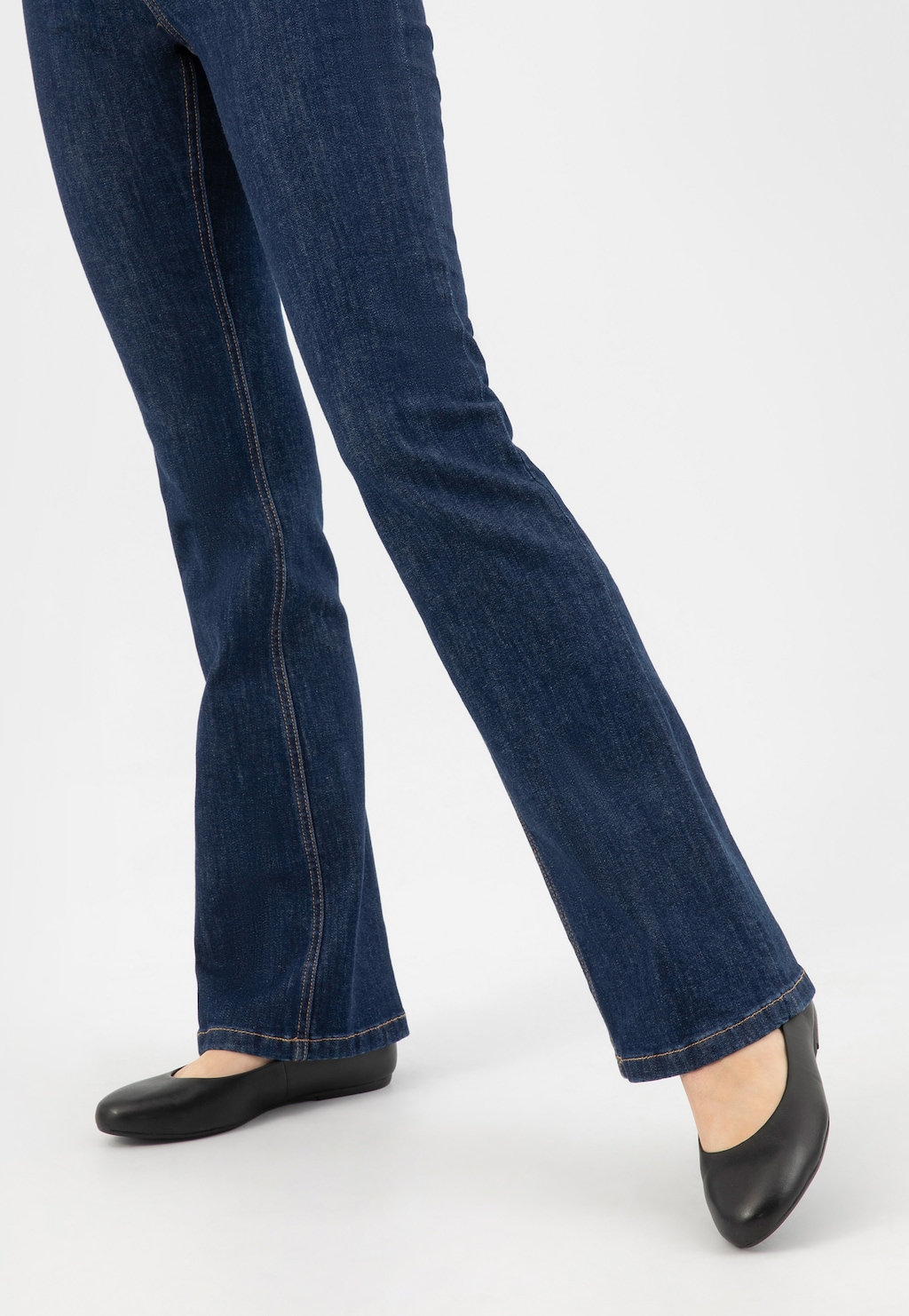 Nogi w granatowych jeansach z czarnymi balerinami Wojas model 44024-51 ze skóry licowej. Eleganckie baleriny idealnie uzupełniają codzienny, casualowy strój.