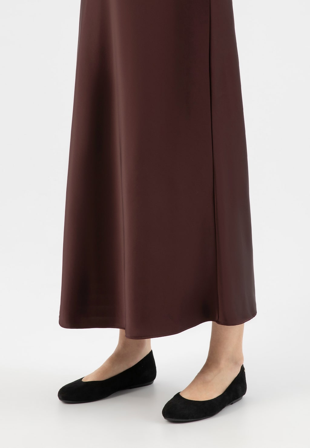 Czarne welurowe baleriny Wojas model 44024-61 z zaokrąglonym noskiem na nogach kobiety w brązowej długiej spódnicy. Eleganckie obuwie damskie w klasycznym stylu.