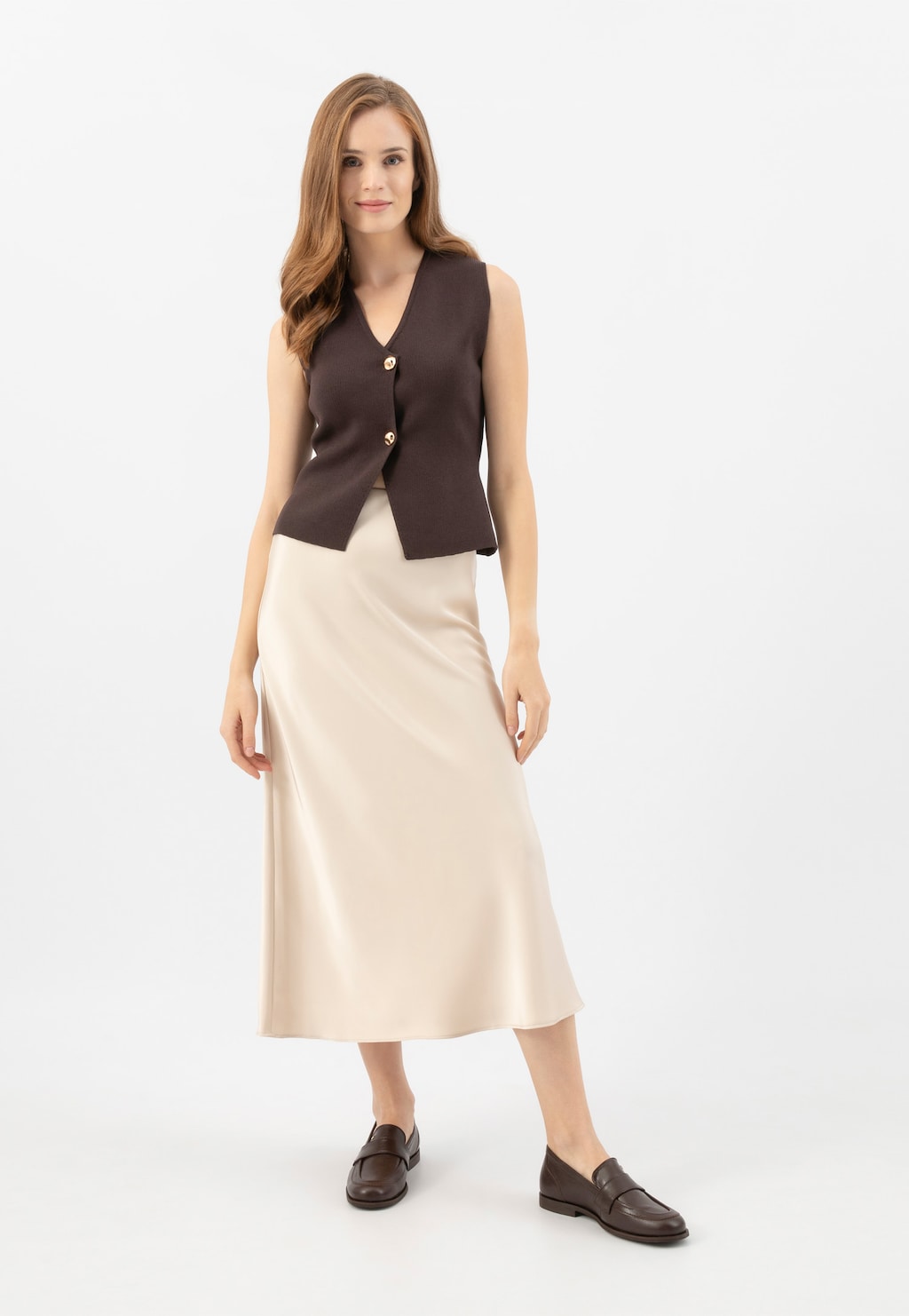 Elegancki outfit z długą beżową spódnicą i brązową kamizelką, uzupełniony brązowymi mokasynami damskimi Wojas ze skóry naturalnej model 46314-52.