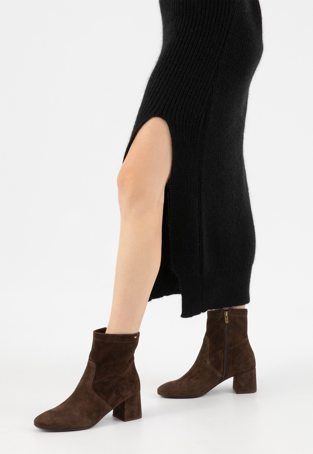 Brązowe jesienne botki Wojas model 55094-62 na niskim obcasie, prezentowane na nogach osoby w czarnej dzianinowej sukience z rozcięciem po boku.