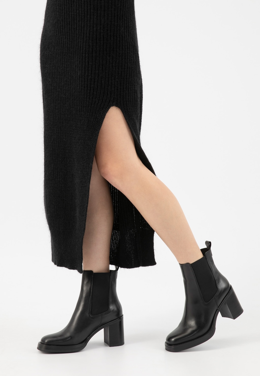 Czarne klasyczne botki Wojas model 55260-51 na stabilnym obcasie prezentowane na nogach w długiej czarnej spódnicy z rozporkiem, ukazujące elegancki i uniwersalny charakter obuwia.