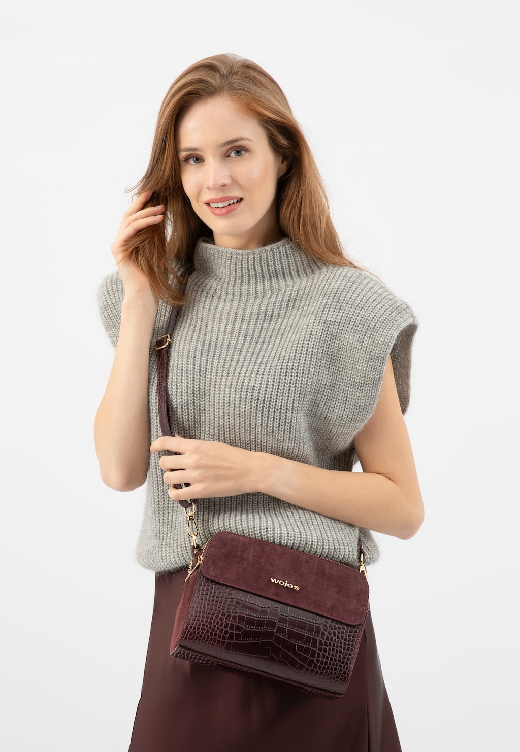 Elegancka bordowa torebka Wojas model 80290-75 z tłoczonej skóry i dwoiny, prezentowana z szarym swetrem bez rękawów. Torebka posiada złote detale i pasek na ramię.