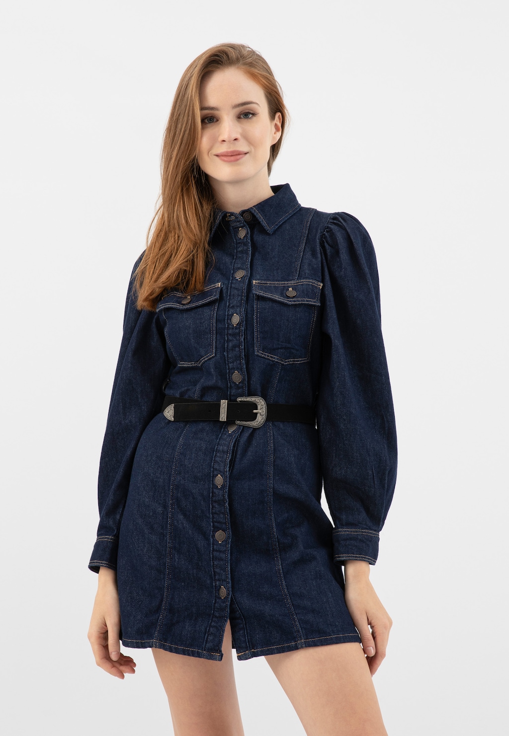 Jeansowa sukienka z czarnym paskiem kowbojskim Wojas 93112-61 z ozdobną klamrą, podkreślającym talię. Krótka sukienka ma zapięcie na guziki i kieszenie na piersi.