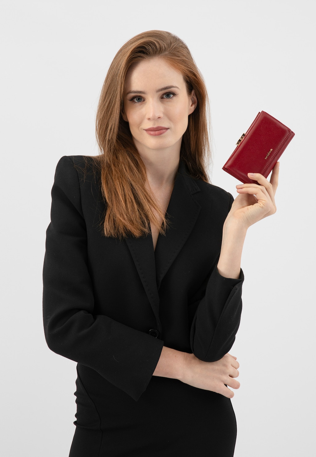 Osoba w czarnym stroju trzymająca czerwony skórzany portfel damski Wojas model 91085-55 z zapięciem na zatrzask, prezentujący elegancki i praktyczny dodatek.