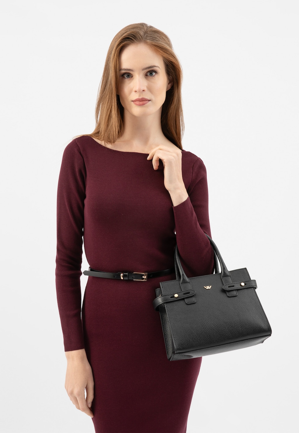 Elegancka modelka w bordowej sukience prezentująca czarną torebkę damską Wojas typu kuferek model 80405-51 z charakterystycznymi uchwytami i złotymi detalami.