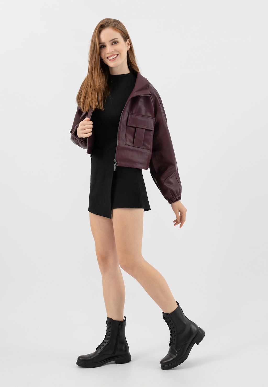 Modelka w czarnej sukience i bordowej kurtce prezentuje czarne skórzane trzewiki damskie Wojas model 64026-59 z ociepleniem, doskonałe na zimowe dni.