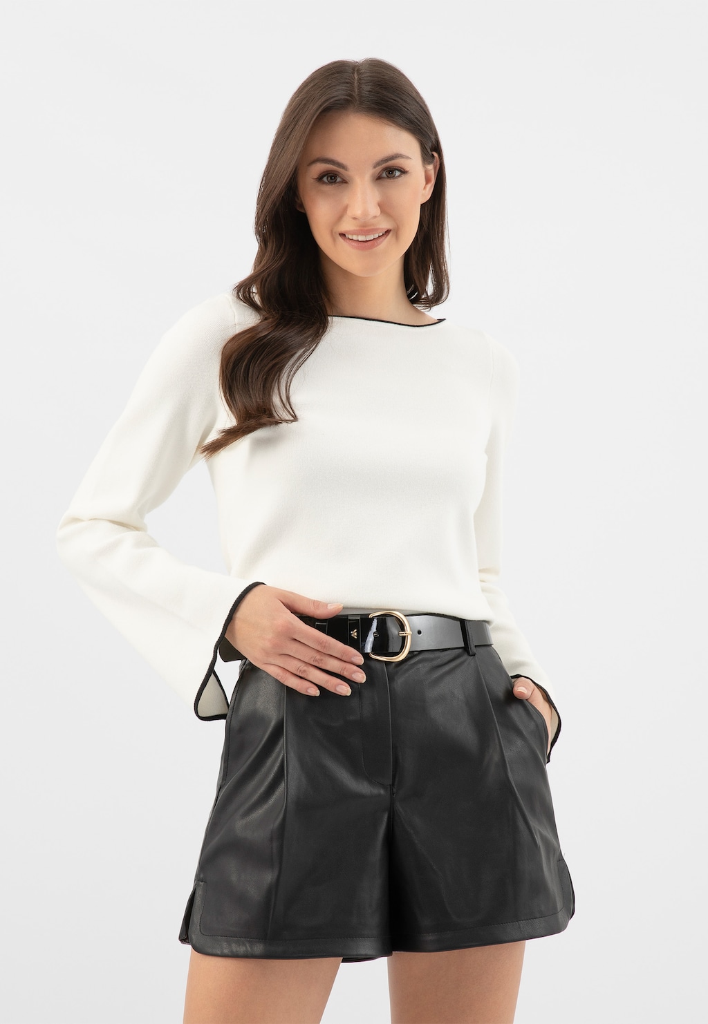 Elegancki czarny pasek damski Wojas model 93088-31 ze skóry lakierowanej, widoczny na modelce noszącej białą bluzkę i czarne skórzane szorty.