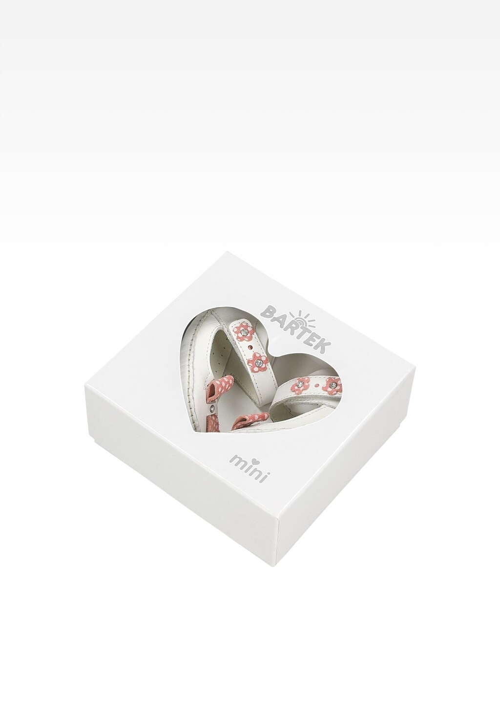 Białe buciki dziecięce Mini BARTEK T-21372/0CF dla dziewczynki z różowymi kwiatowymi zdobieniami i kokardkami, zapakowane w eleganckie pudełko z okienkiem w kształcie serca.
