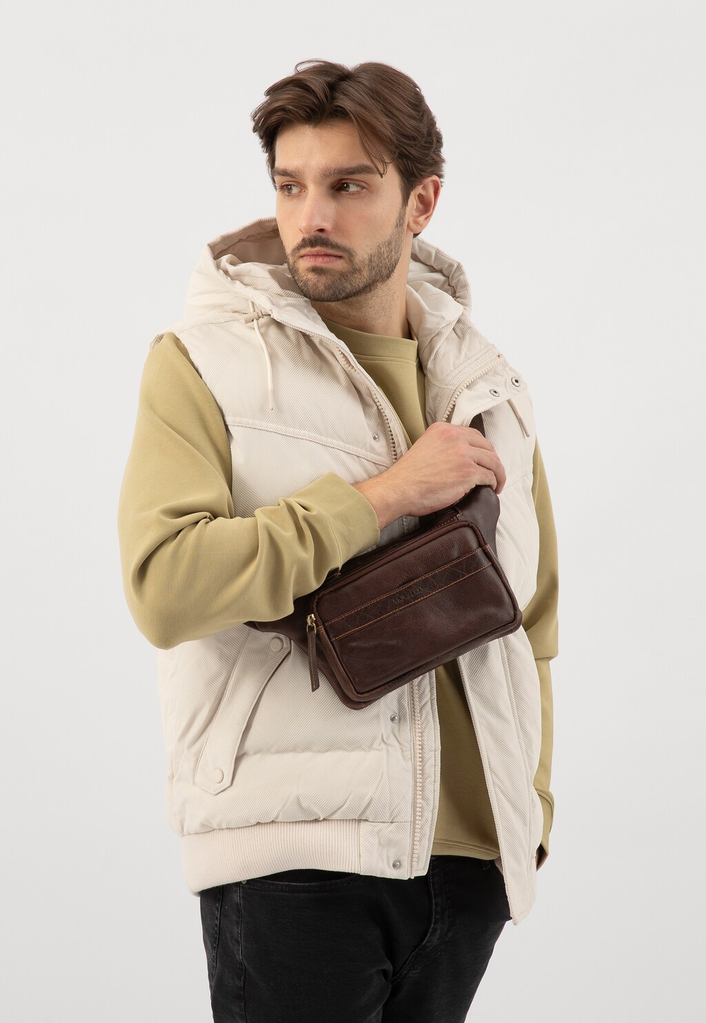 Skórzana brązowa nerka męska Wojas model 90022-52 prezentowana na modelu ubranym w beżową kamizelkę z kapturem i oliwkową bluzę. Praktyczna torba na ramieniu.