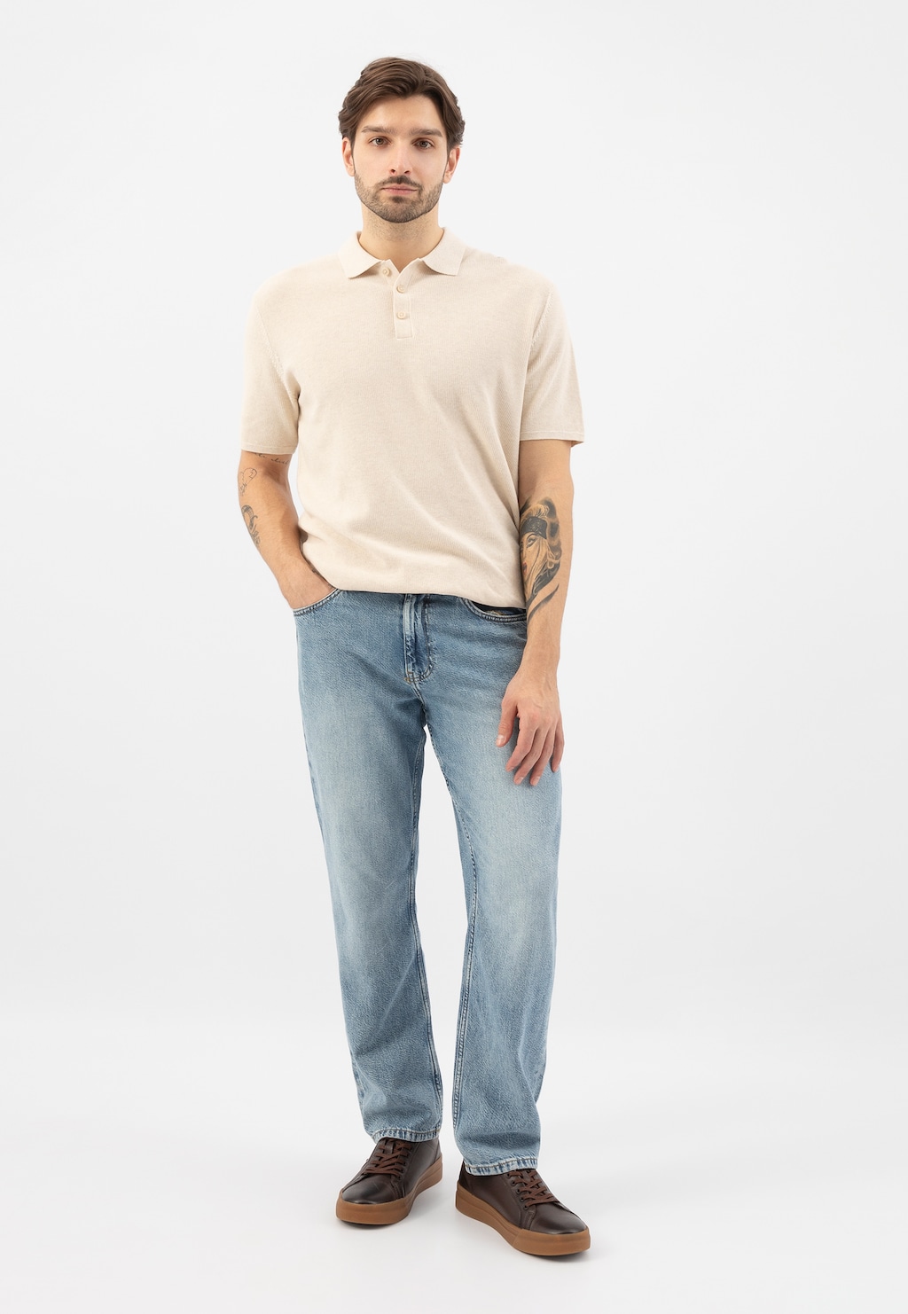 Model ubrany w jasną koszulkę polo i jasnoniebieskie jeansy, prezentuje brązowe trampki Wojas model 10228-52 z jaśniejszymi wstawkami i gumową podeszwą.