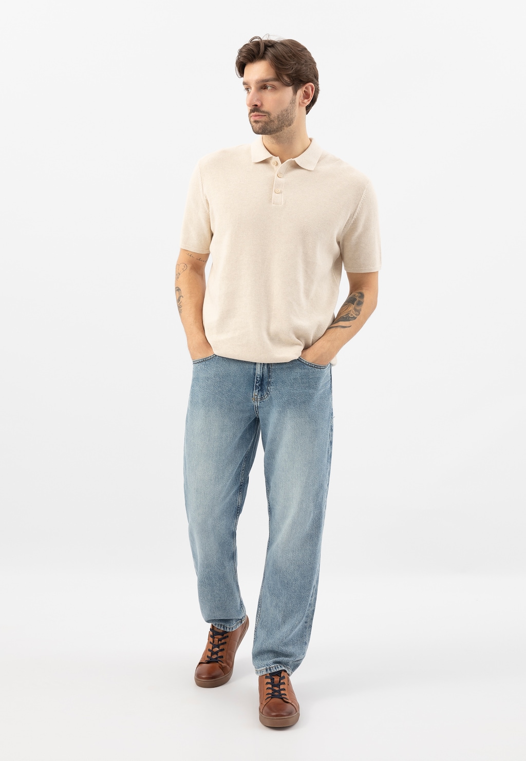 Osoba w beżowej koszulce polo i jasnych jeansach prezentująca brązowe trampki Wojas model 10222-53 z ciemnymi wstawkami, z rękami w kieszeniach.