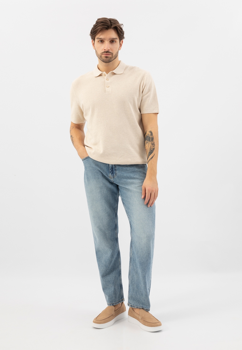 Beżowe mokasyny męskie Wojas 10218-64 na białej podeszwie zaprezentowane w stylizacji z jasną koszulką polo i jasnymi jeansami.