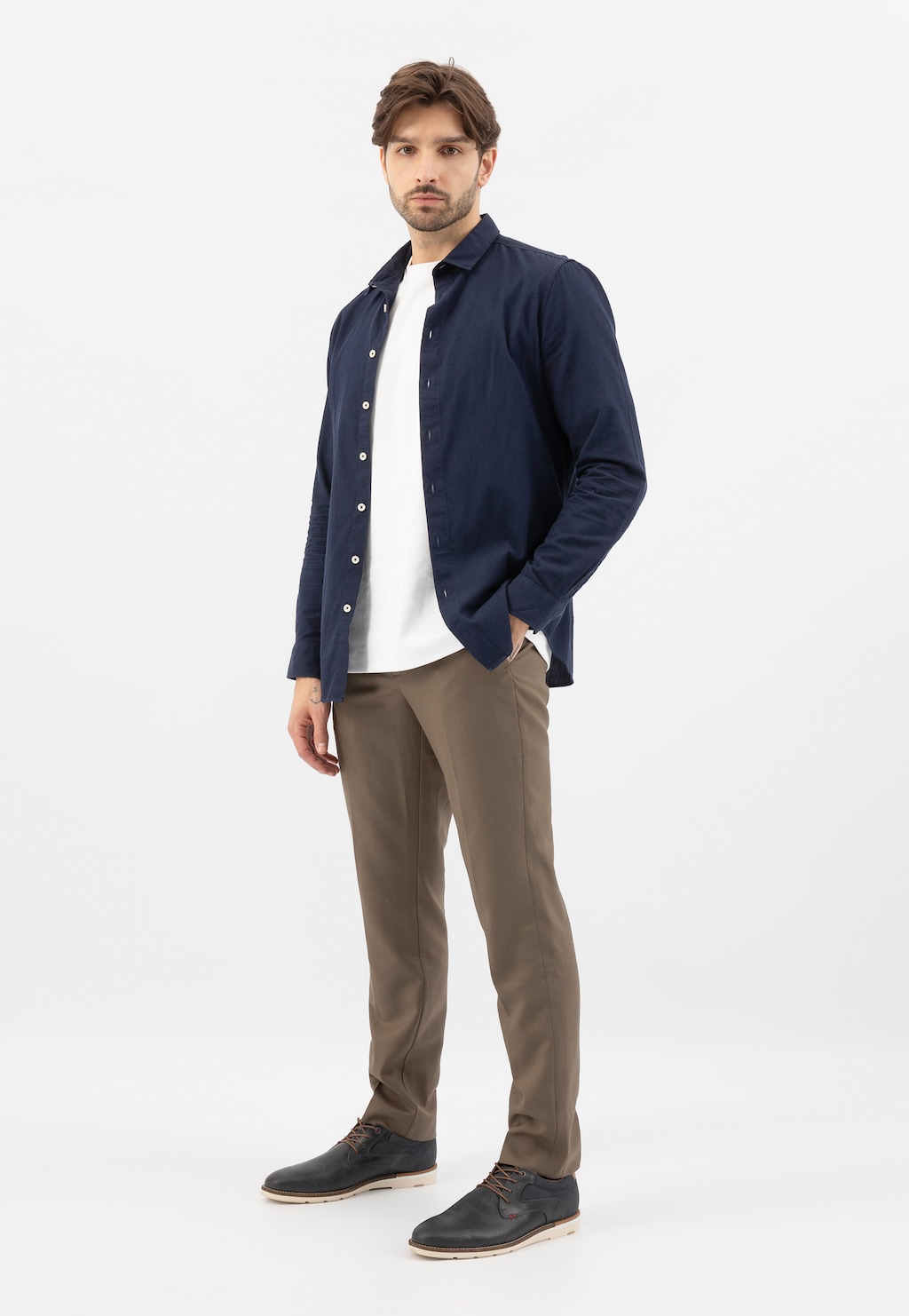 Mężczyzna w eleganckim stroju z granatowymi półbutami Wojas model 10211-76 z brązowymi wstawkami, widocznymi w stylizacji z granatową koszulą i brązowymi spodniami.