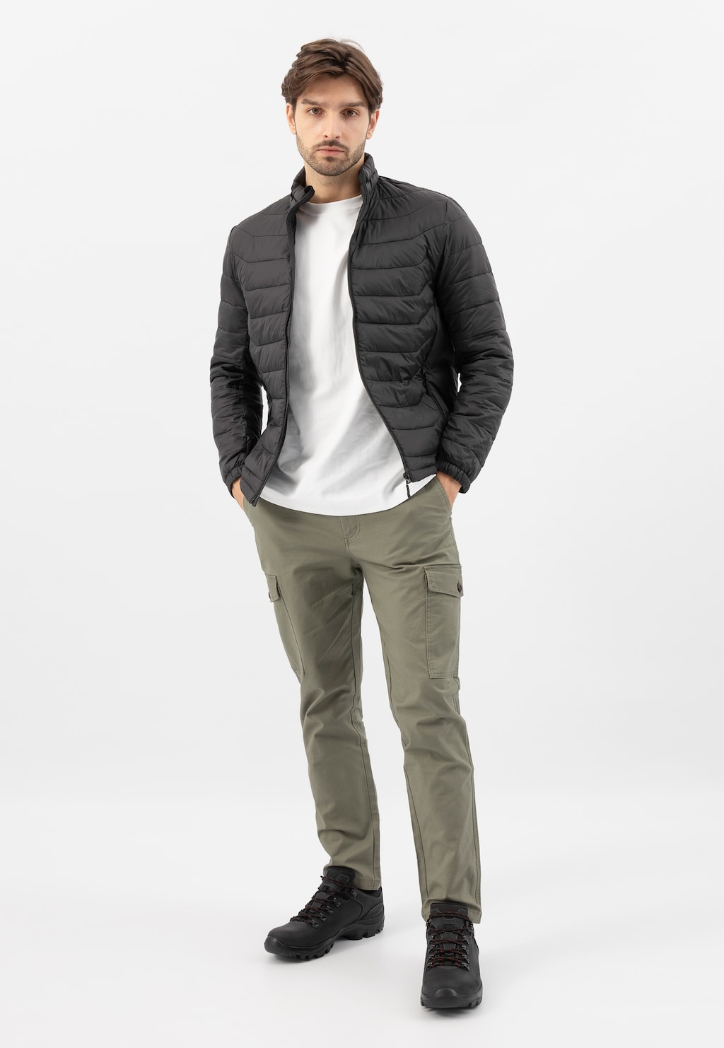 Model w czarnej pikowanej kurtce, białej koszulce i oliwkowych spodniach cargo, prezentujący czarne męskie półbuty Wojas model 9377-91 w stylizacji casualowej.