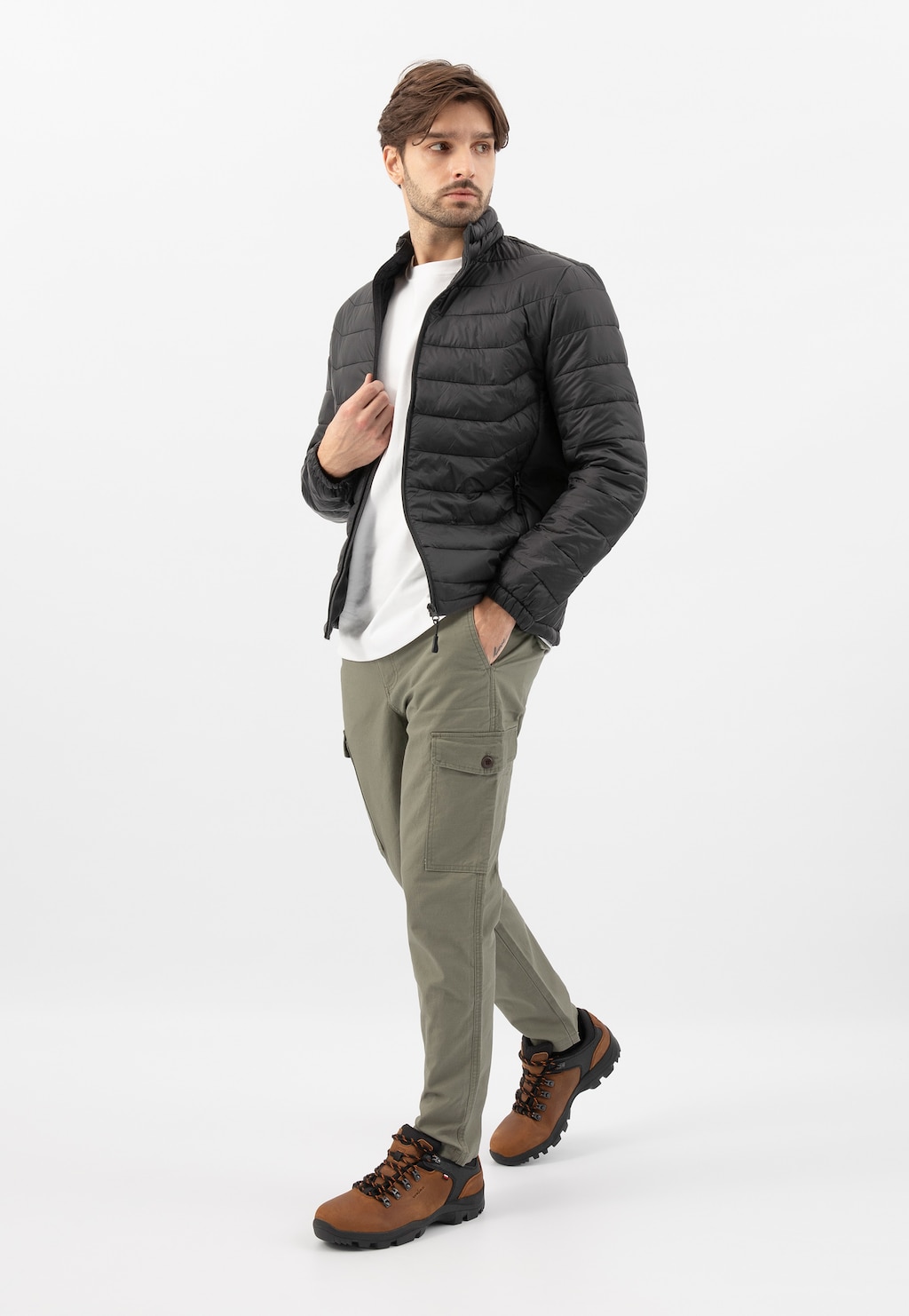 Brązowe buty trekkingowe Wojas model 9377-83 prezentowane na modelu w stylizacji z czarną pikowaną kurtką, białym t-shirtem i zielonymi spodniami cargo.
