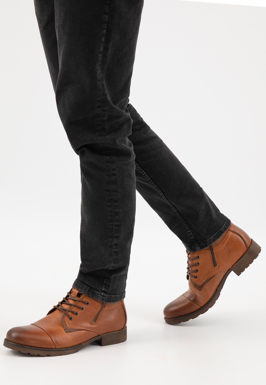 Brązowe trzewiki męskie Wojas model 8234-73 na nogach mężczyzny w czarnych jeansach, widok z boku pokazujący eleganckie buty ze sznurowaniem i bocznym zamkiem.