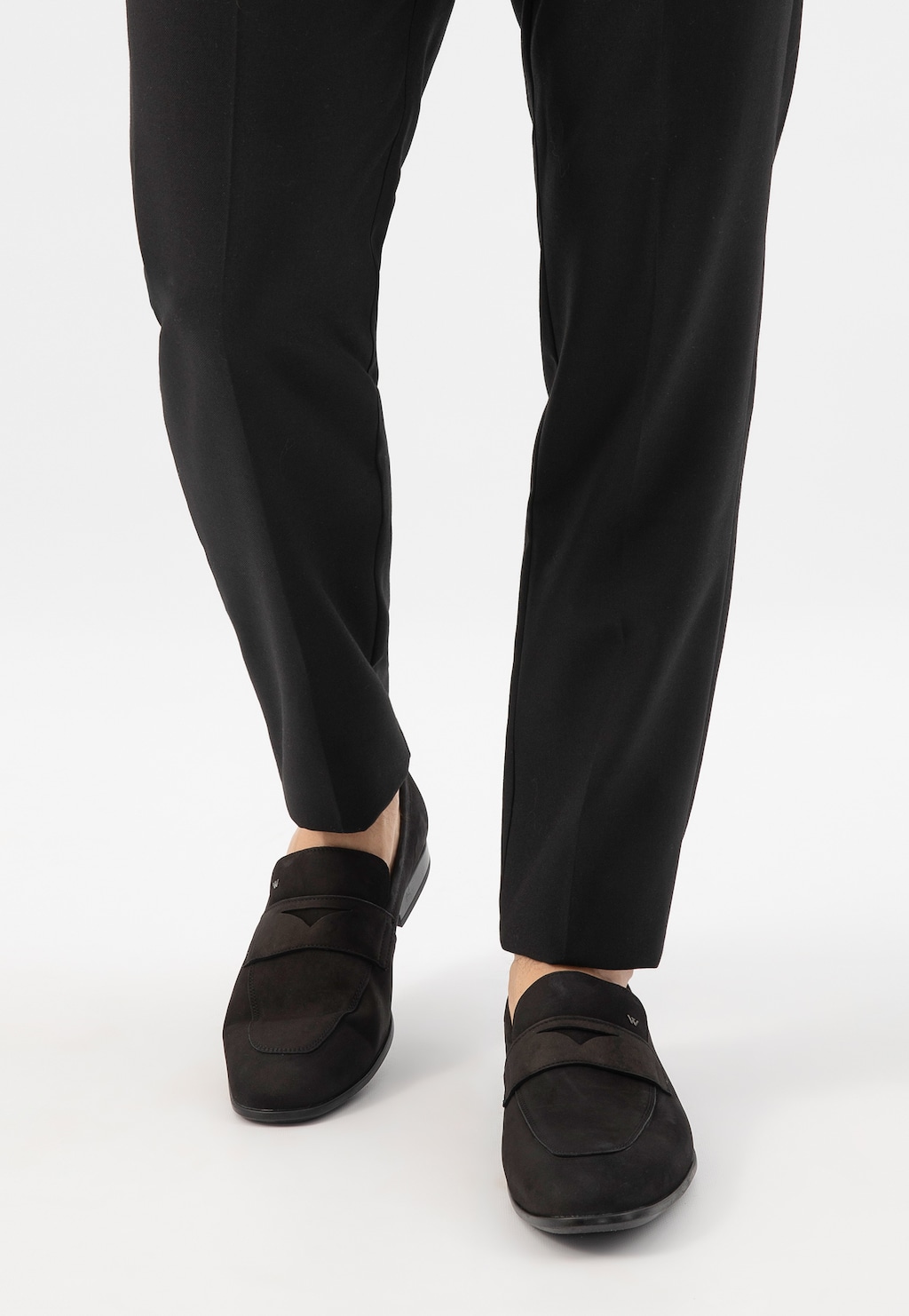 Czarne loafersy męskie Wojas model 10196-21 wykonane z nubuku, widoczne na nogach osoby w eleganckich czarnych spodniach. Klasyczny design butów idealny do stylizacji biznesowych.