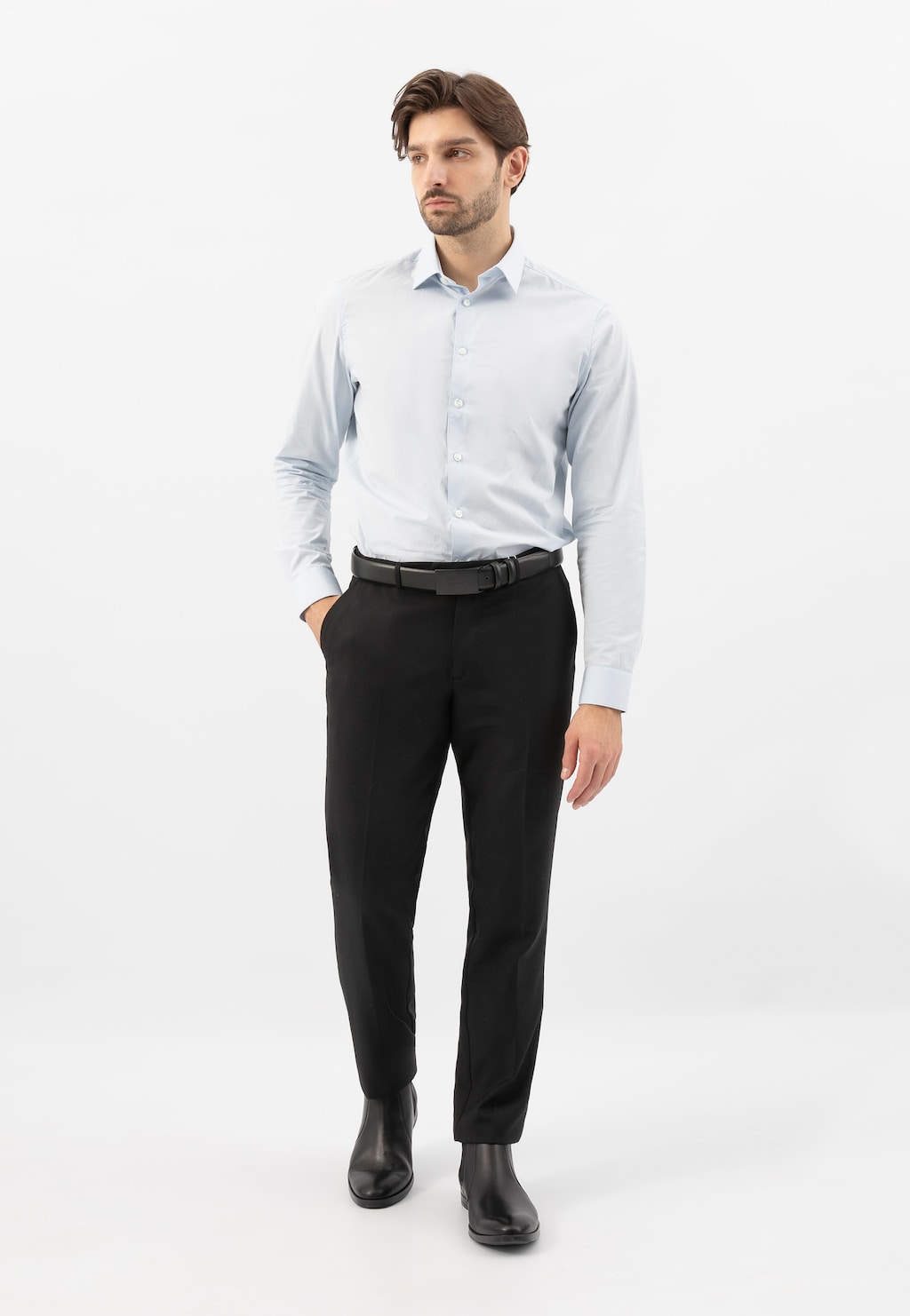 Elegancki mężczyzna w jasnej koszuli i czarnych spodniach prezentujący czarne sztyblety Wojas model 20003-50 ze skóry licowej, idealne do formalnych stylizacji.