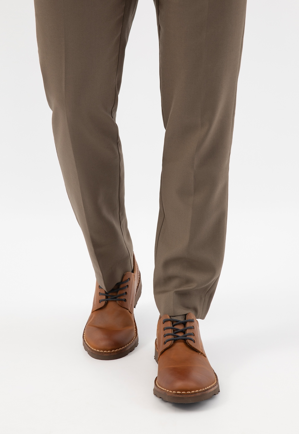 Jasnobrązowe męskie półbuty Wojas model 5084-73 z czarnymi sznurówkami, widoczne na nogach w beżowych spodniach. Eleganckie buty o skórzanej fakturze.