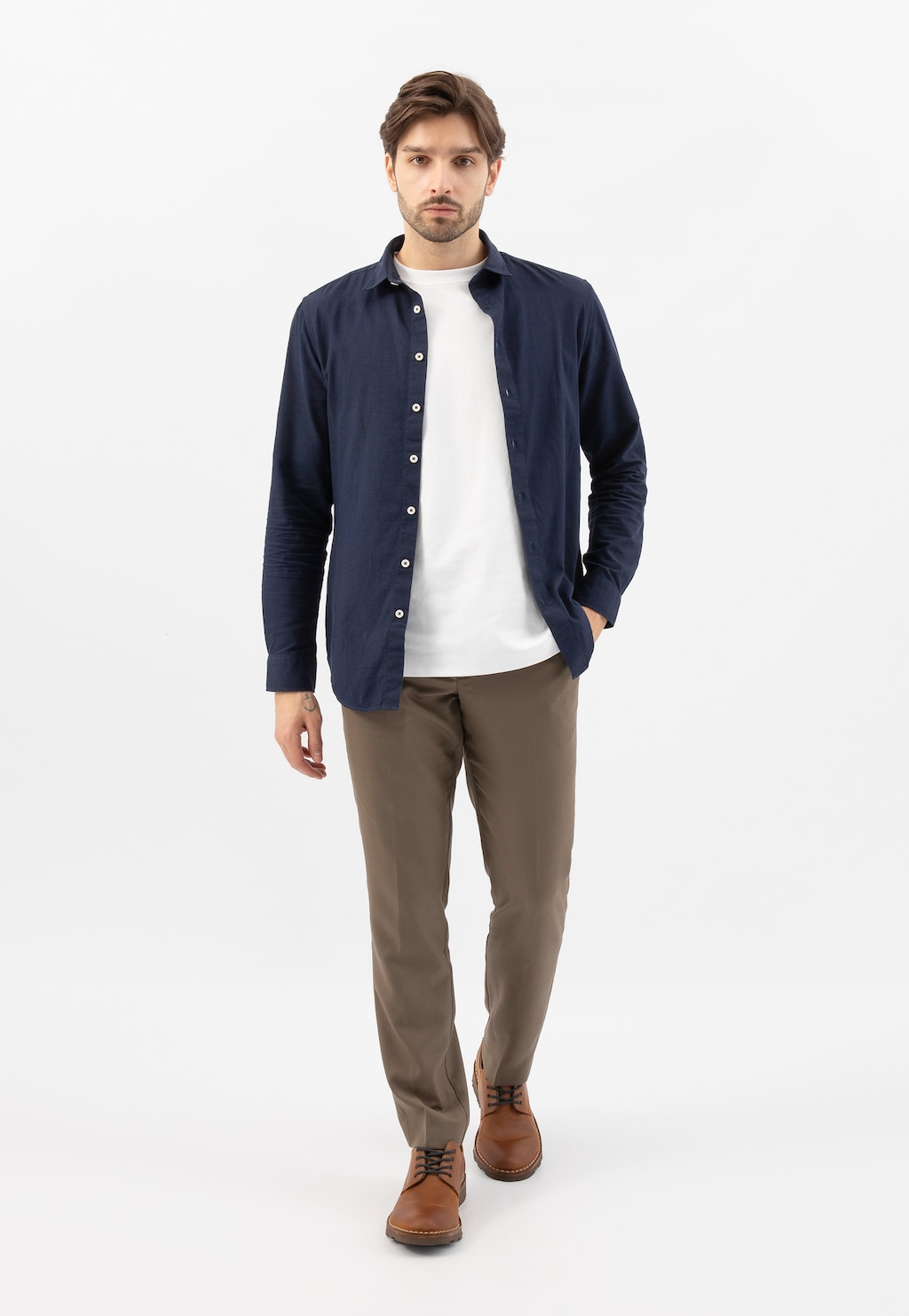 Model w casualowej stylizacji prezentujący jasnobrązowe męskie półbuty Wojas 5084-73, widoczne z granatową koszulą i beżowymi spodniami na białym tle.