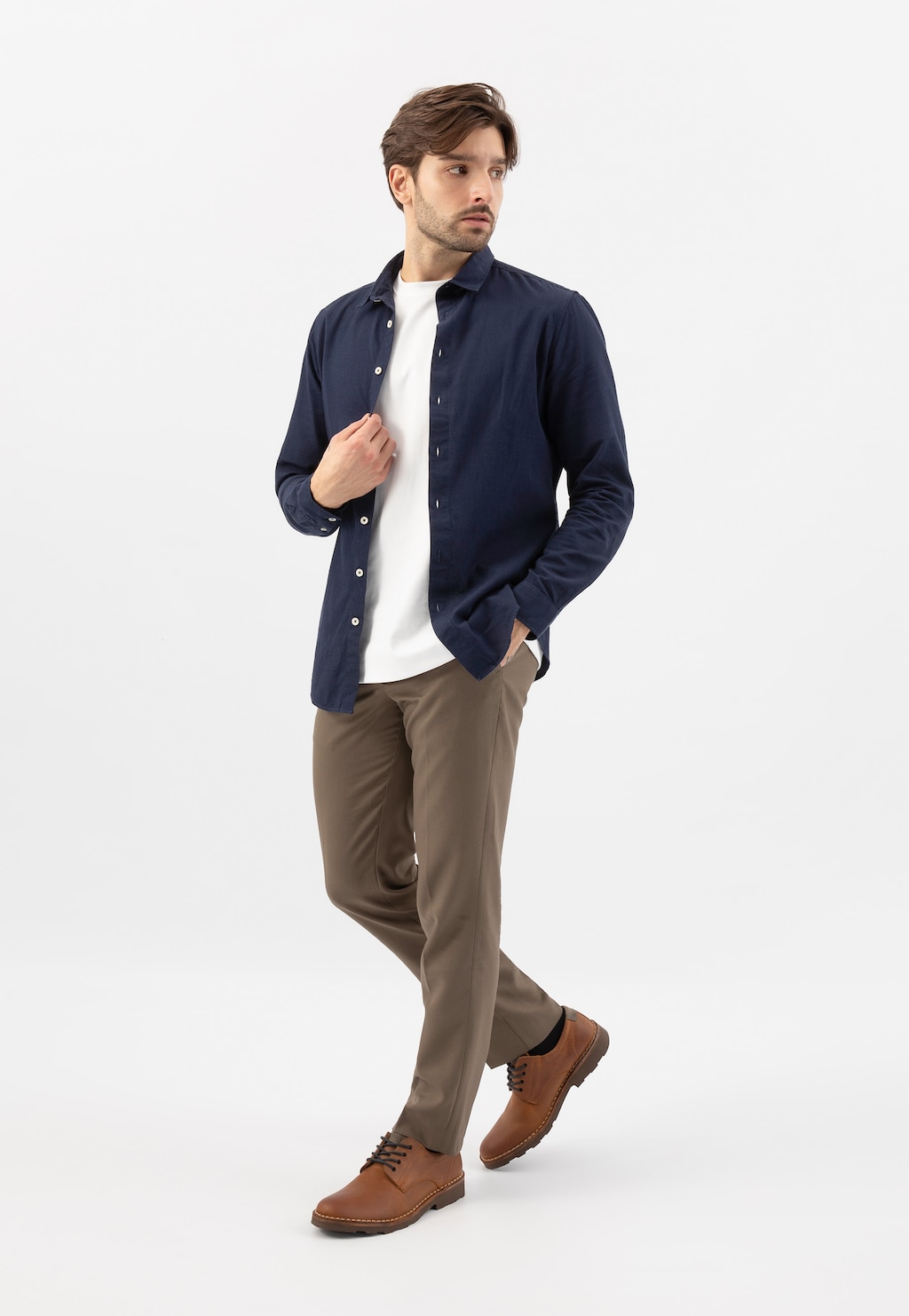 Model w eleganckiej stylizacji z granatową koszulą, białym t-shirtem i brązowymi spodniami, prezentujący jasnobrązowe półbuty Wojas model 5084-73 o casualowym charakterze.