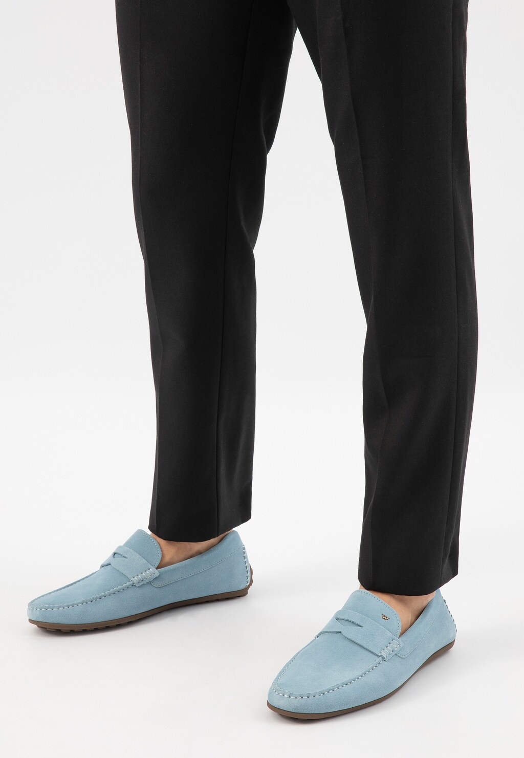 Niebieskie mokasyny męskie Wojas model 10116-69 na stopach mężczyzny w czarnych spodniach. Zamszowe buty wiosenne z charakterystycznym przeszyciem i gumową podeszwą.