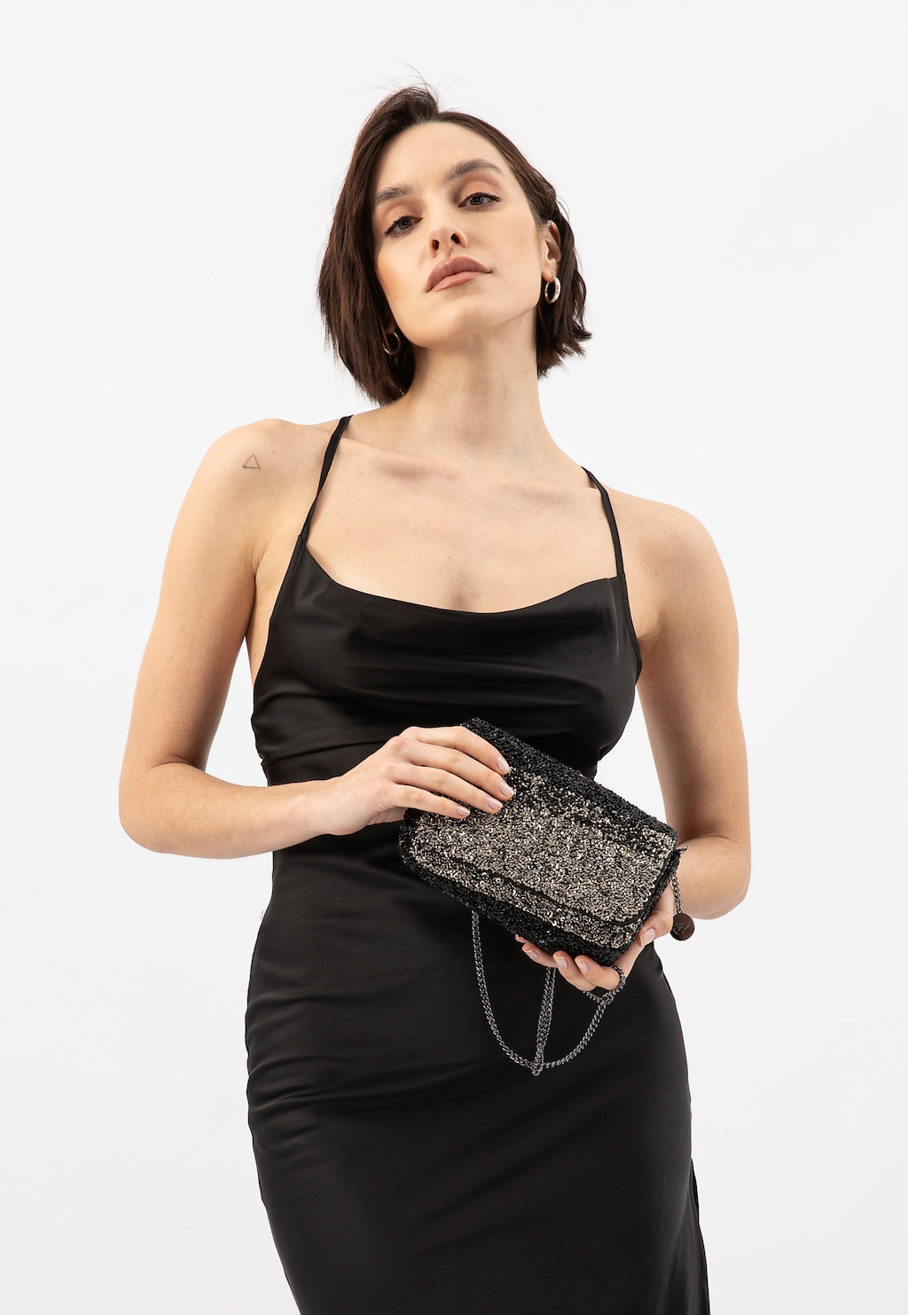 Elegancka czarna torebka wizytowa Wojas model 80432-81 z ozdobnymi koralikami, trzymana w dłoniach. Idealne uzupełnienie wieczorowej stylizacji.