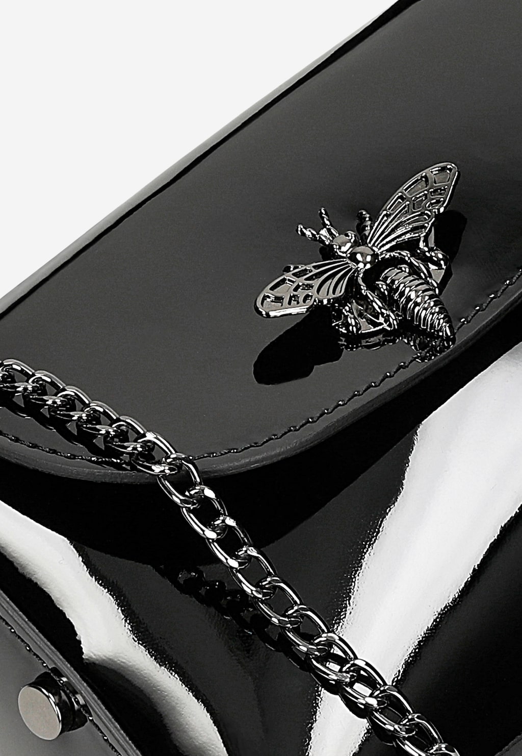 Elegancka czarna lakierowana torebka wizytowa Wojas model 80318-31 z metalową ozdobą w kształcie owada i łańcuszkiem. Zbliżenie na detale zdobiące powierzchnię.