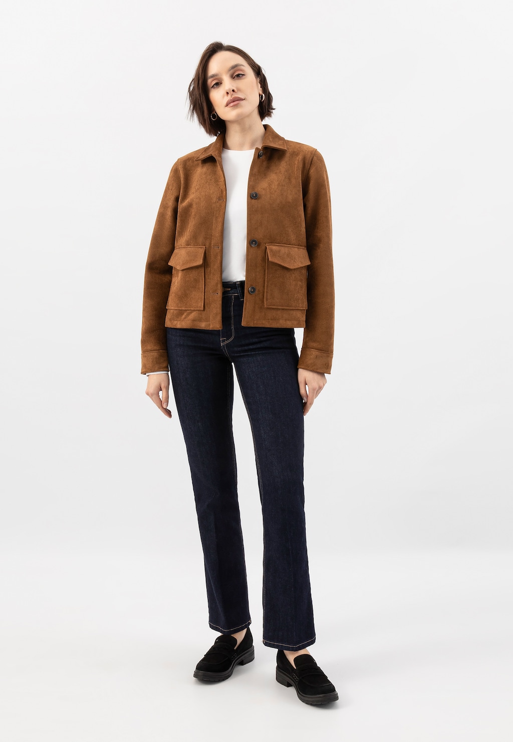 Modelka w stylizacji z czarnymi mokasynami Wojas model 46301-61 z dwoiny welurowej, uzupełniona brązową zamszową kurtką, białą koszulką i granatowymi jeansami.