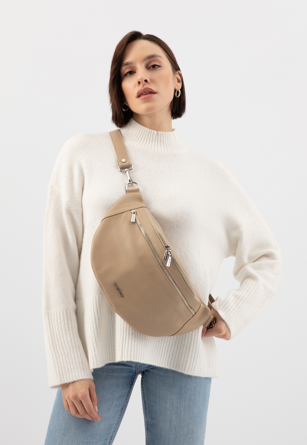 Elegancka skórzana beżowa torebka nerka Wojas model 80298-54 z kieszeniami na zamek, prezentowana na osobie w białym swetrze i jeansach.