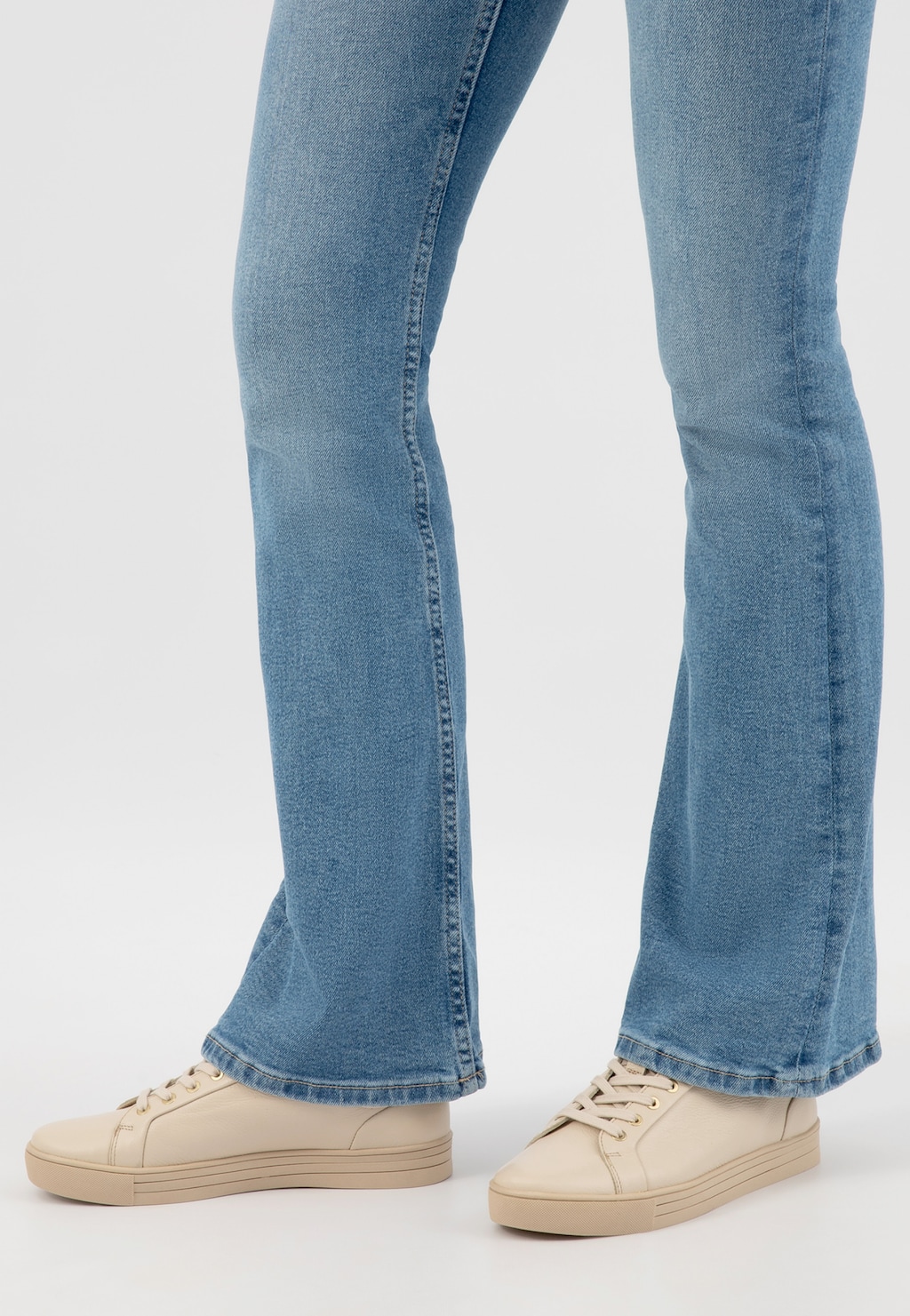 Beżowe trampki damskie Wojas model 46019-54 ze złotymi akcentami, widoczne na nogach osoby w niebieskich dżinsach o prostym kroju.